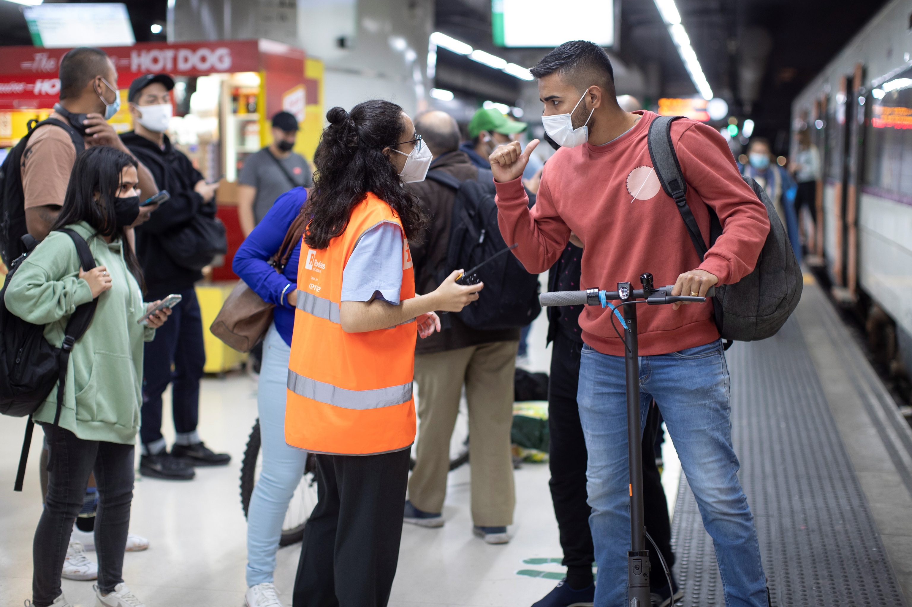 Ante la huelga de Renfe, una informadora atiende a un usuario de Renfe en la Estación de Sants de Barcelona este martes.
