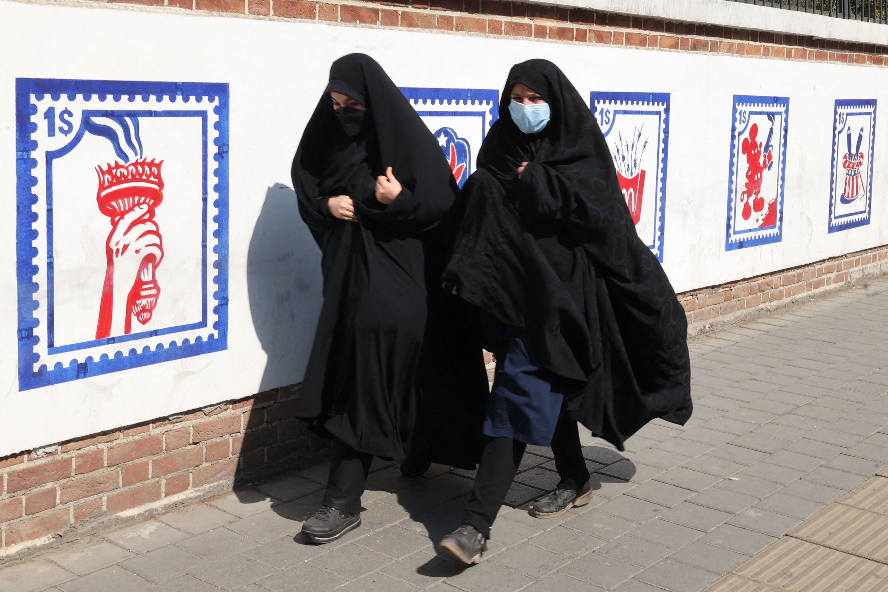 Dos mujeres caminan por una calle de Tehern.