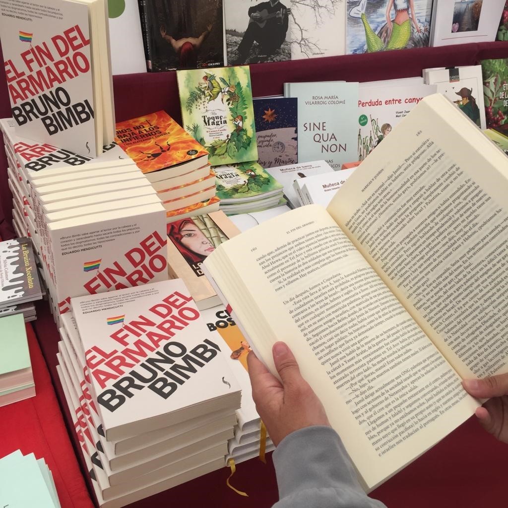 Una lectora consulta el libro de Bruno Bimbi 'El fin del armario'  en la Feria del Libro de Castellón.