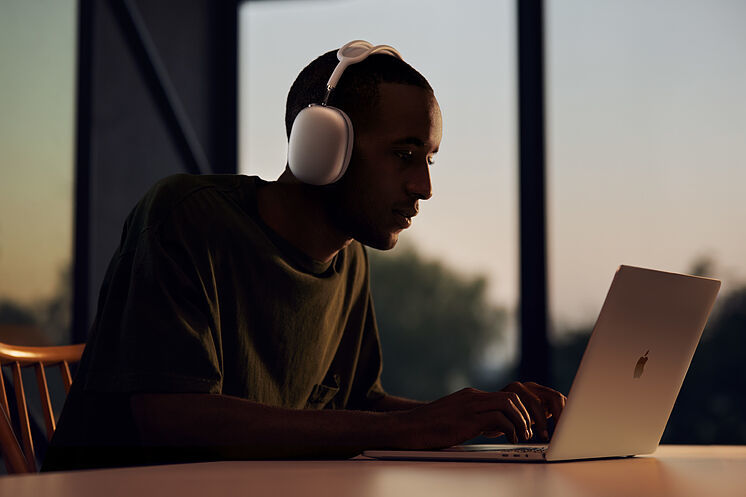 Una persona escucha música conectada a un ordenador.