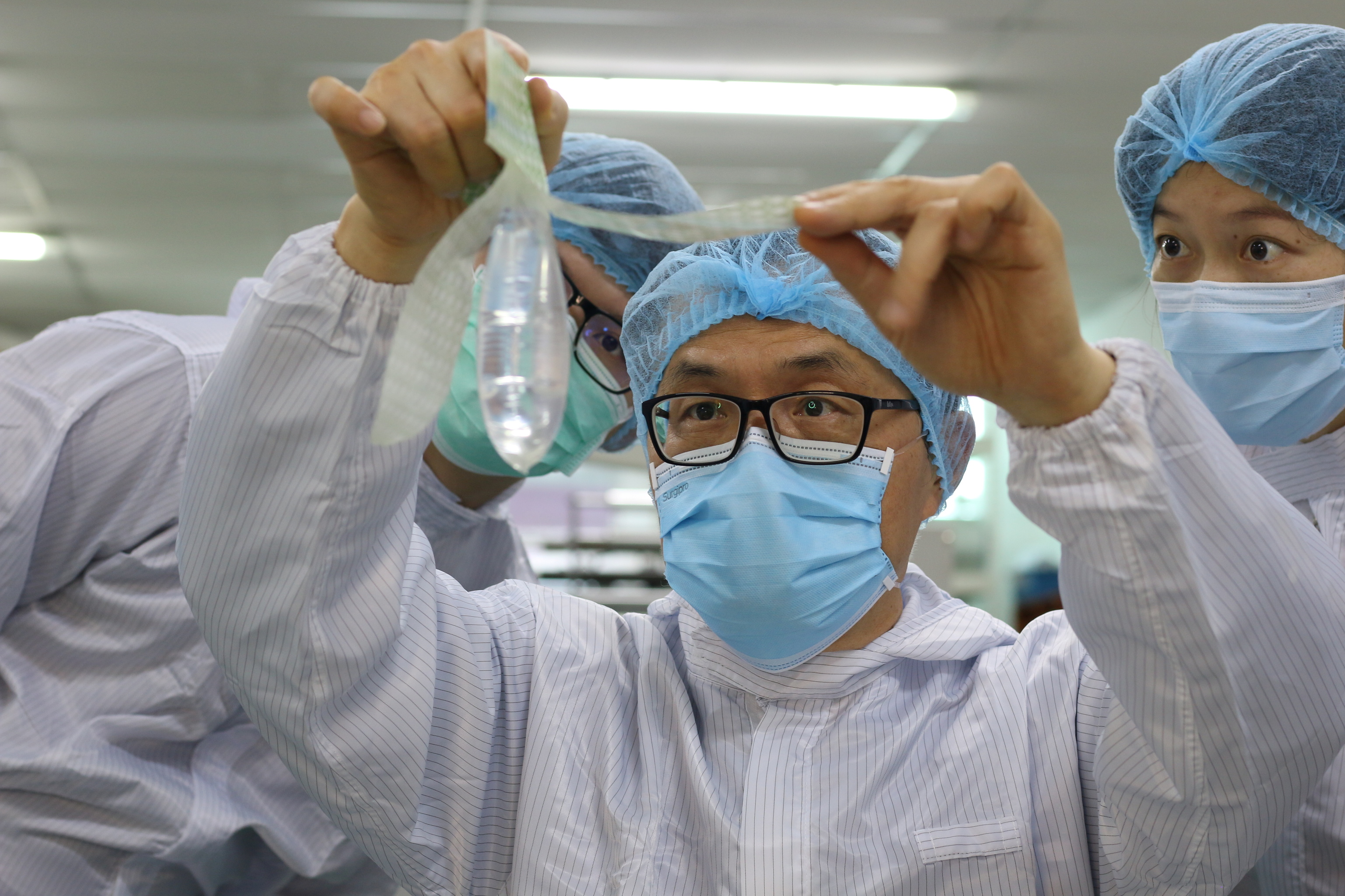 El fundador e inventor del preservativo unisex Wondaleaf, John Tang Ing Ching, inspecciona el preservativo unisex en su fábrica de Sibu, Malasia,