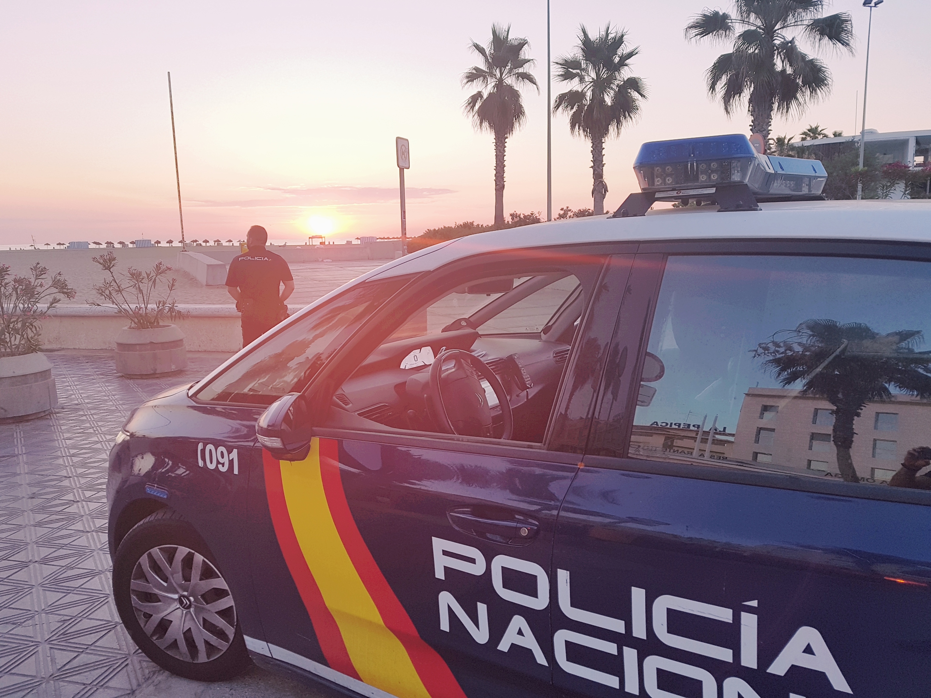 Un coche de la Policía Nacional en la playa de la Malvarrosa.