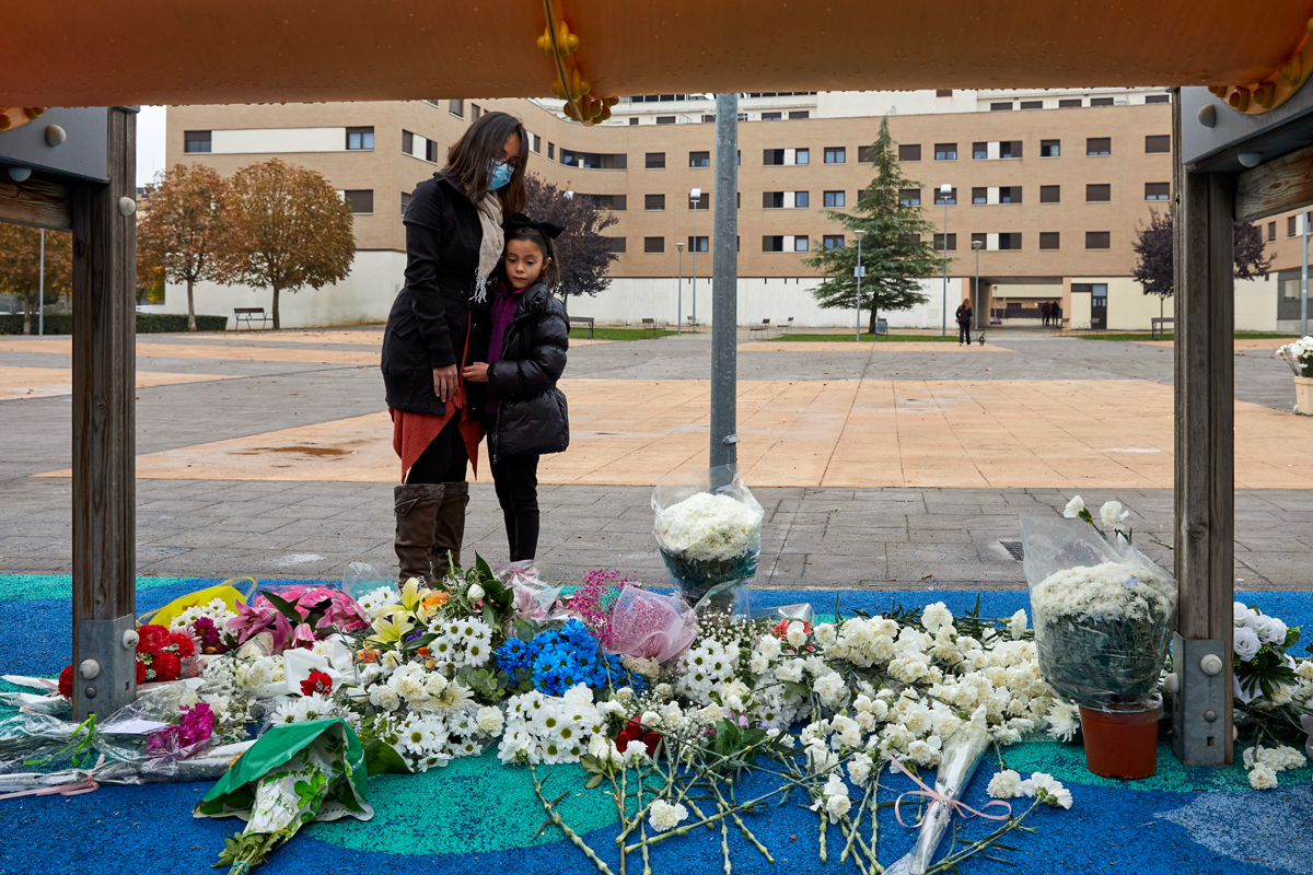 Una madre y su hija observan las flores depositadas en el parque donde fue raptado el menor.