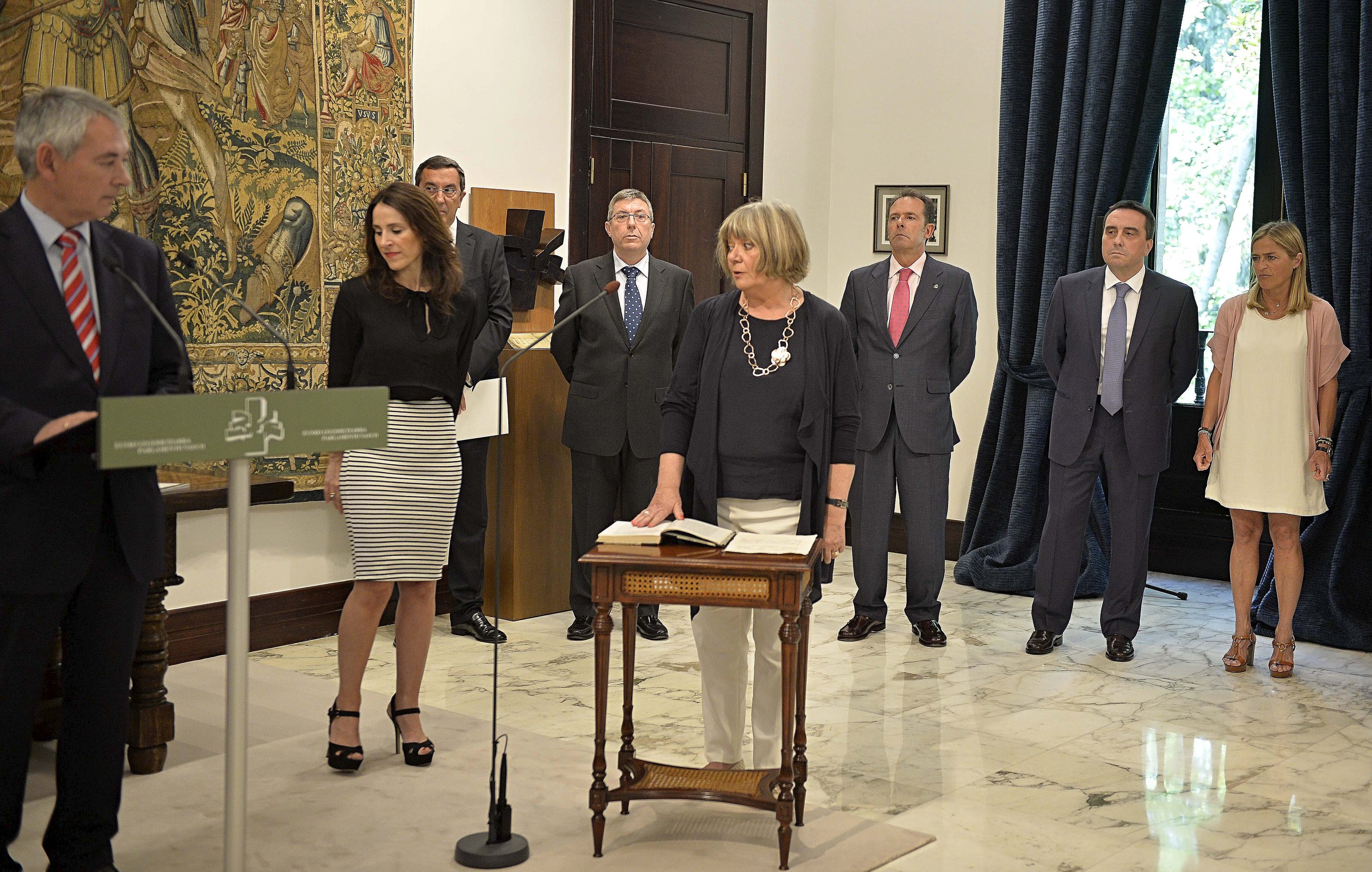 Begoa Marijuan promete su cargo en el Parlamento Vasco ante la mirada de Bakartxo Tejeria con Bilbao en segundo plano.