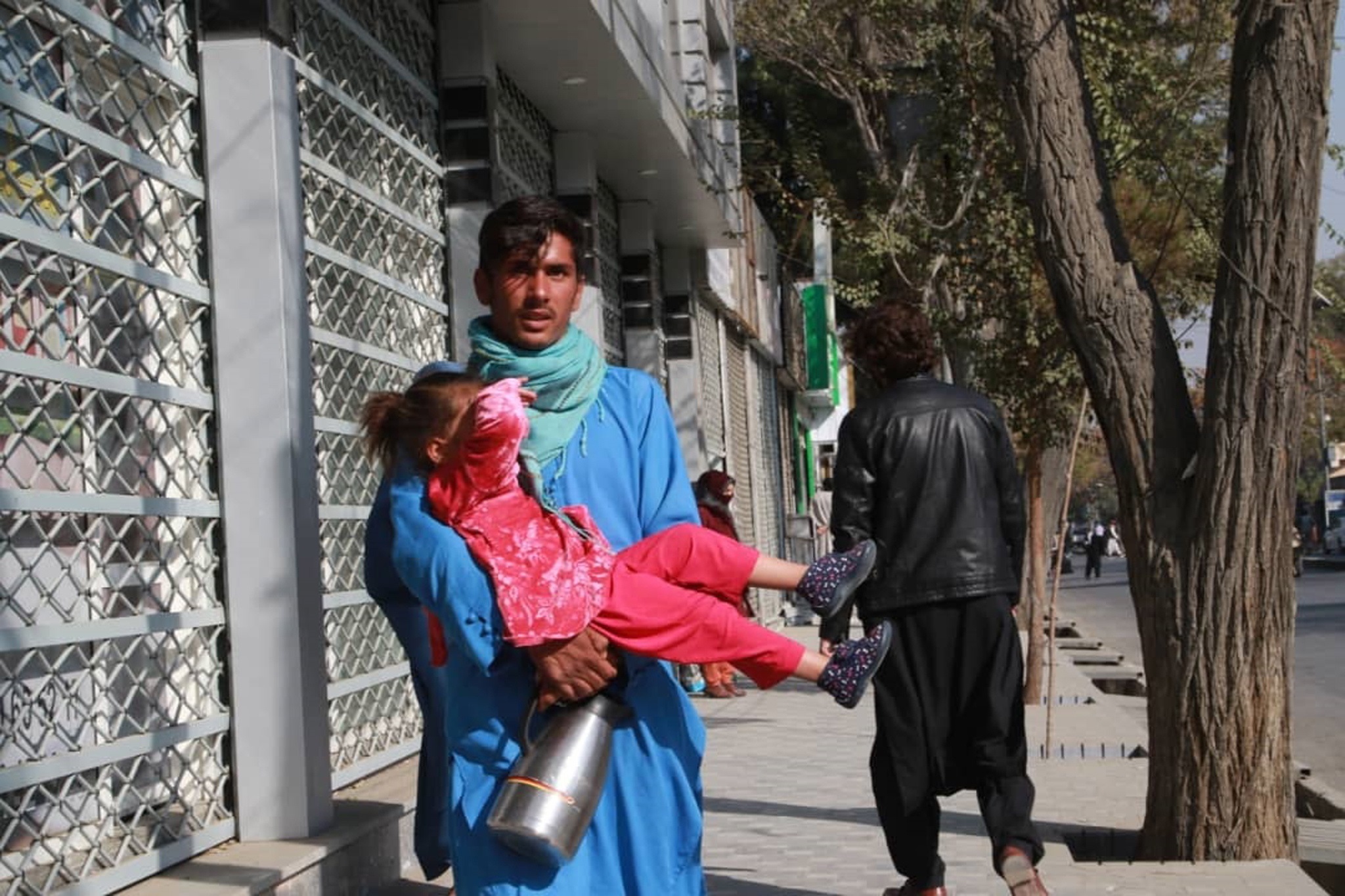 Un padre y su hija huyen del lugar del atentado en Kabul.