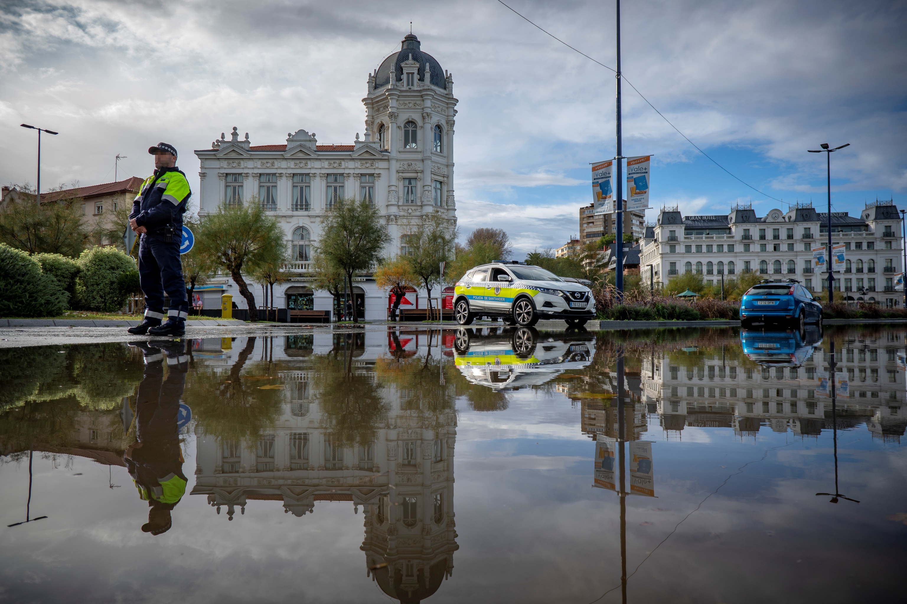 Un polica vigila el acceso a la Plaza de Italia, en Santander, inundada el jueves por las fuertes lluvias.