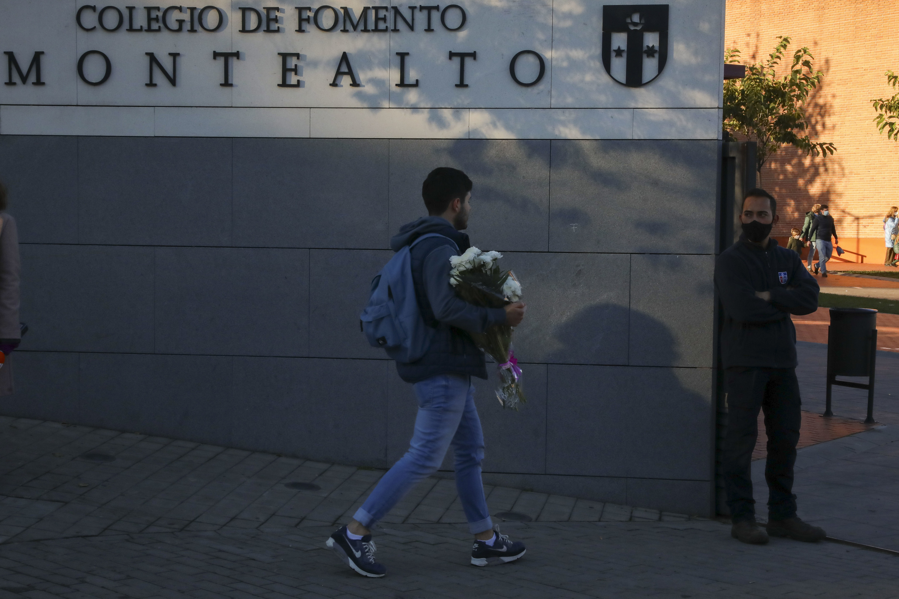 Un estudiante lleva flores al colegio Montealto.