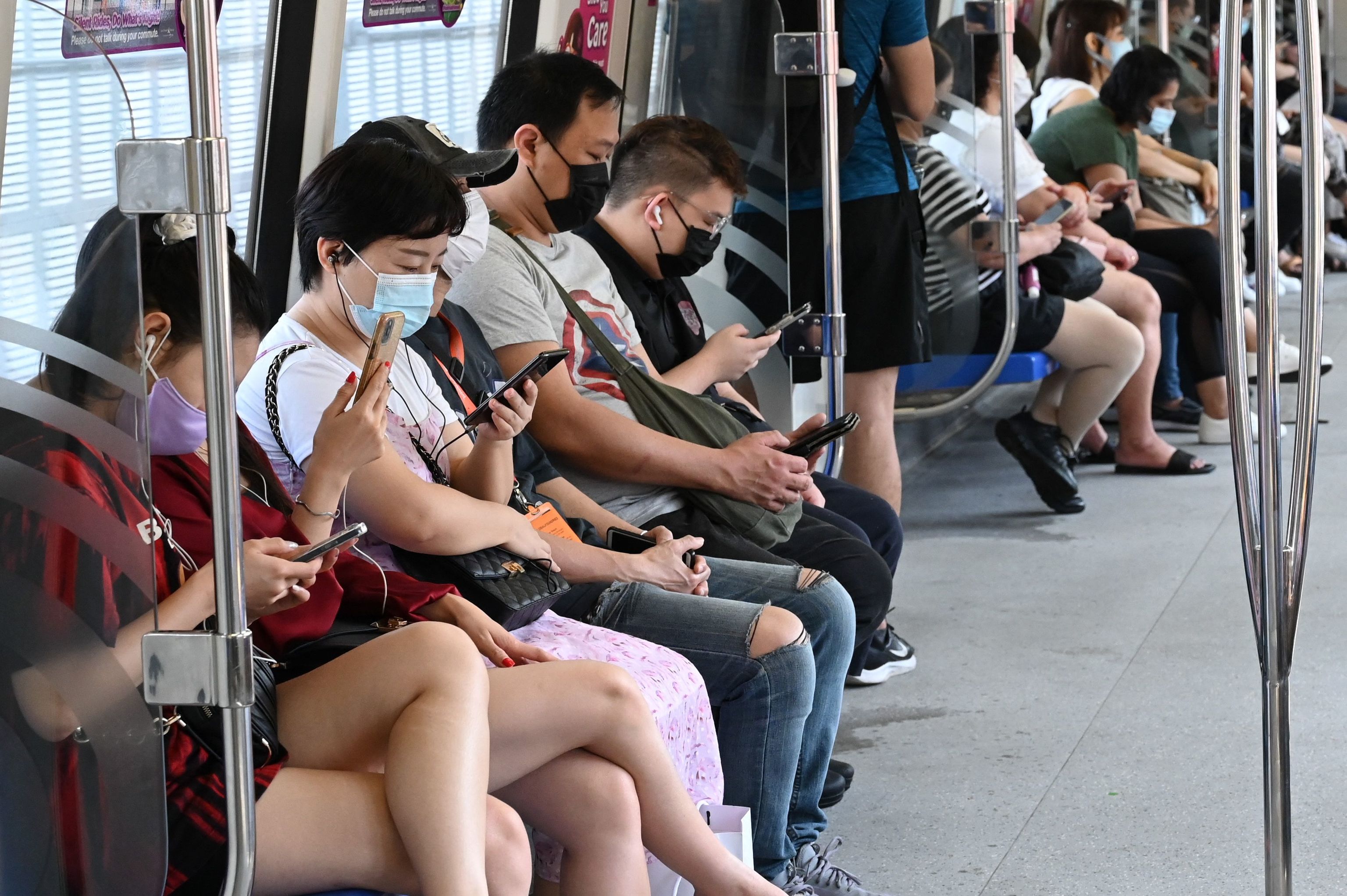 Personas con mascarilla en un tren en Singapur.