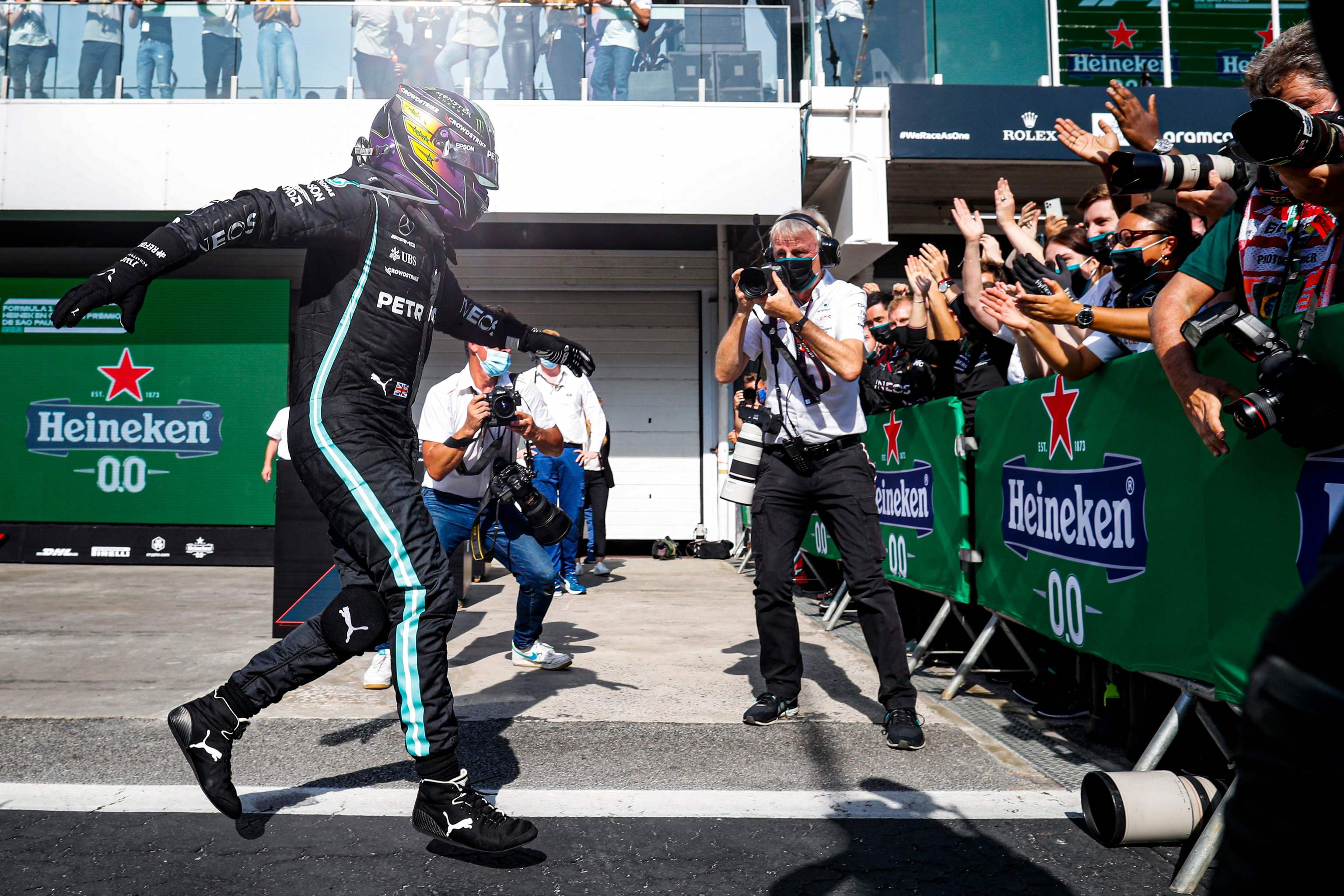 Hamilton festeja con el equipo Mercedes su triunfo en Interlagos.