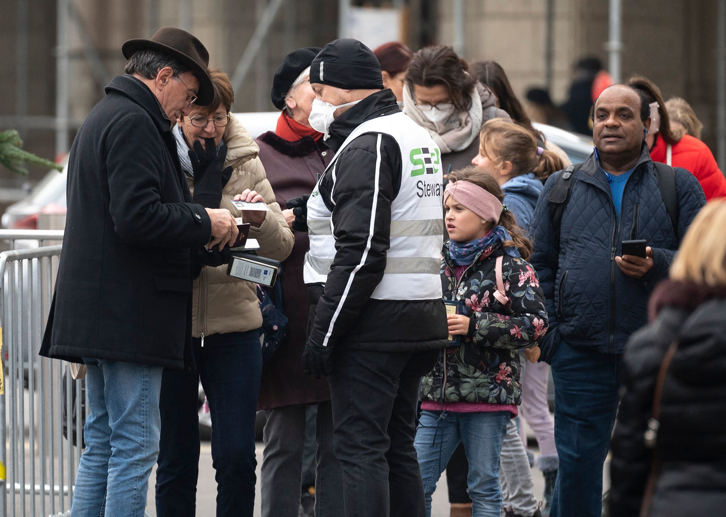 Visitantes de un mercado navideño en Viena enseñan sus pases de vacunación.