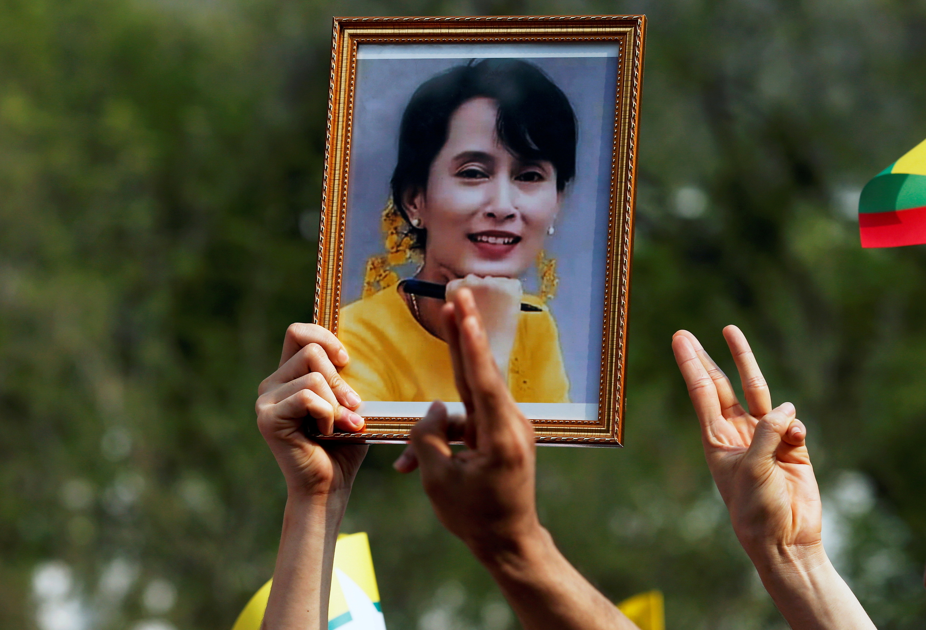 Una persona sostiene un retrato de Suu Kyi durante una protesta por su detención.