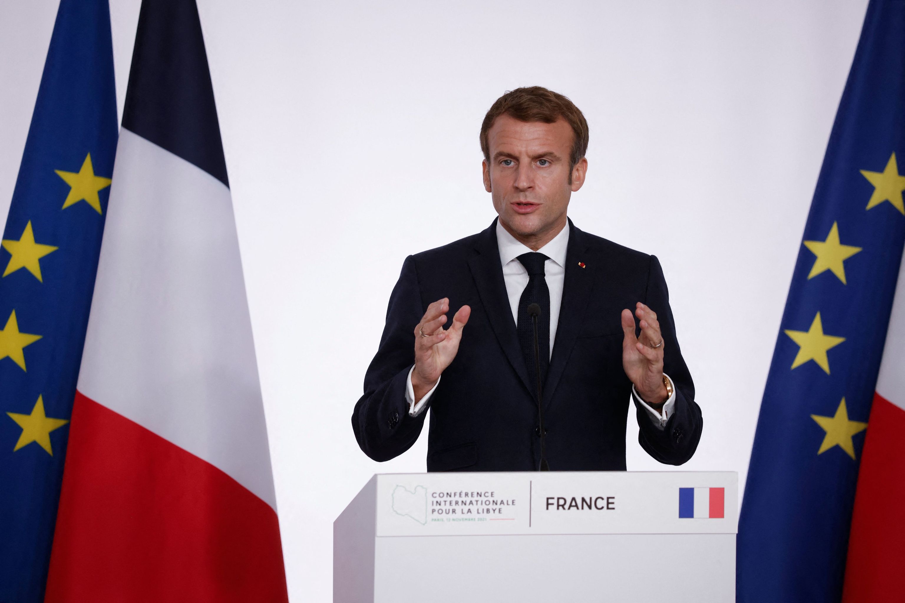 Macron, durante una rueda de prensa, con la bandera de un azul ms oscuro al fondo.