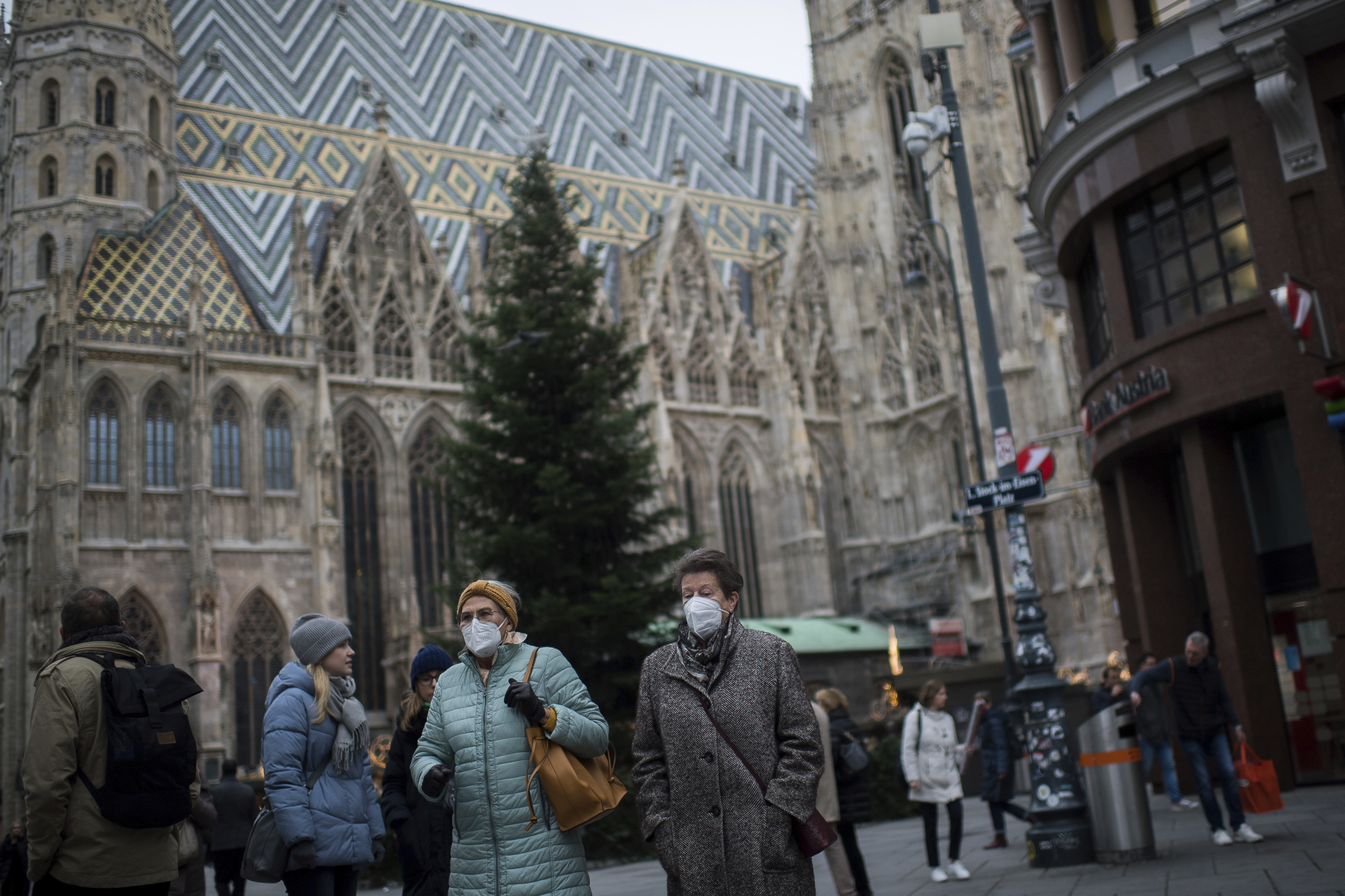 Personas con mascarillas pasean frente a la catedral de Viena.