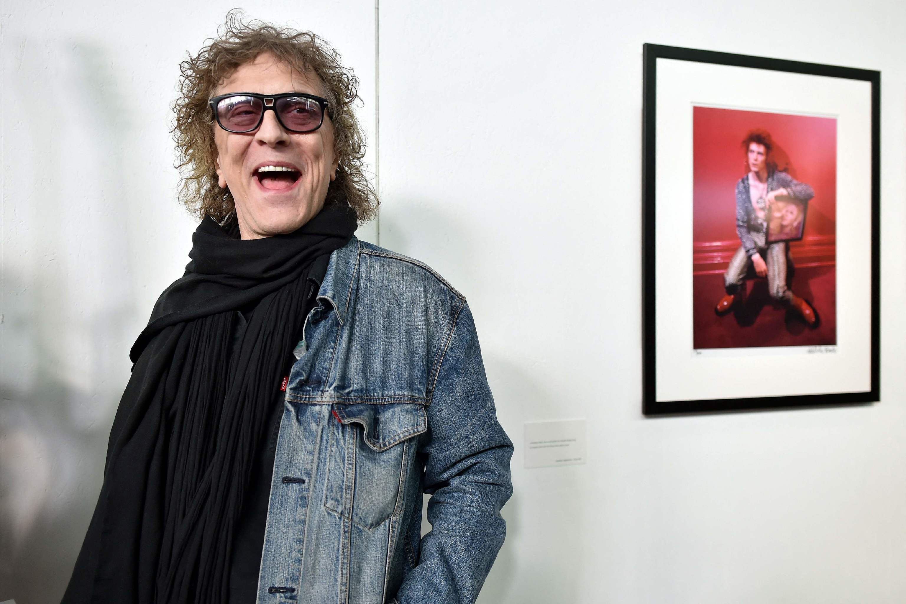 Mick Rock, en una imagen tomada en 2016 junto a una de sus icnicas fotografas.