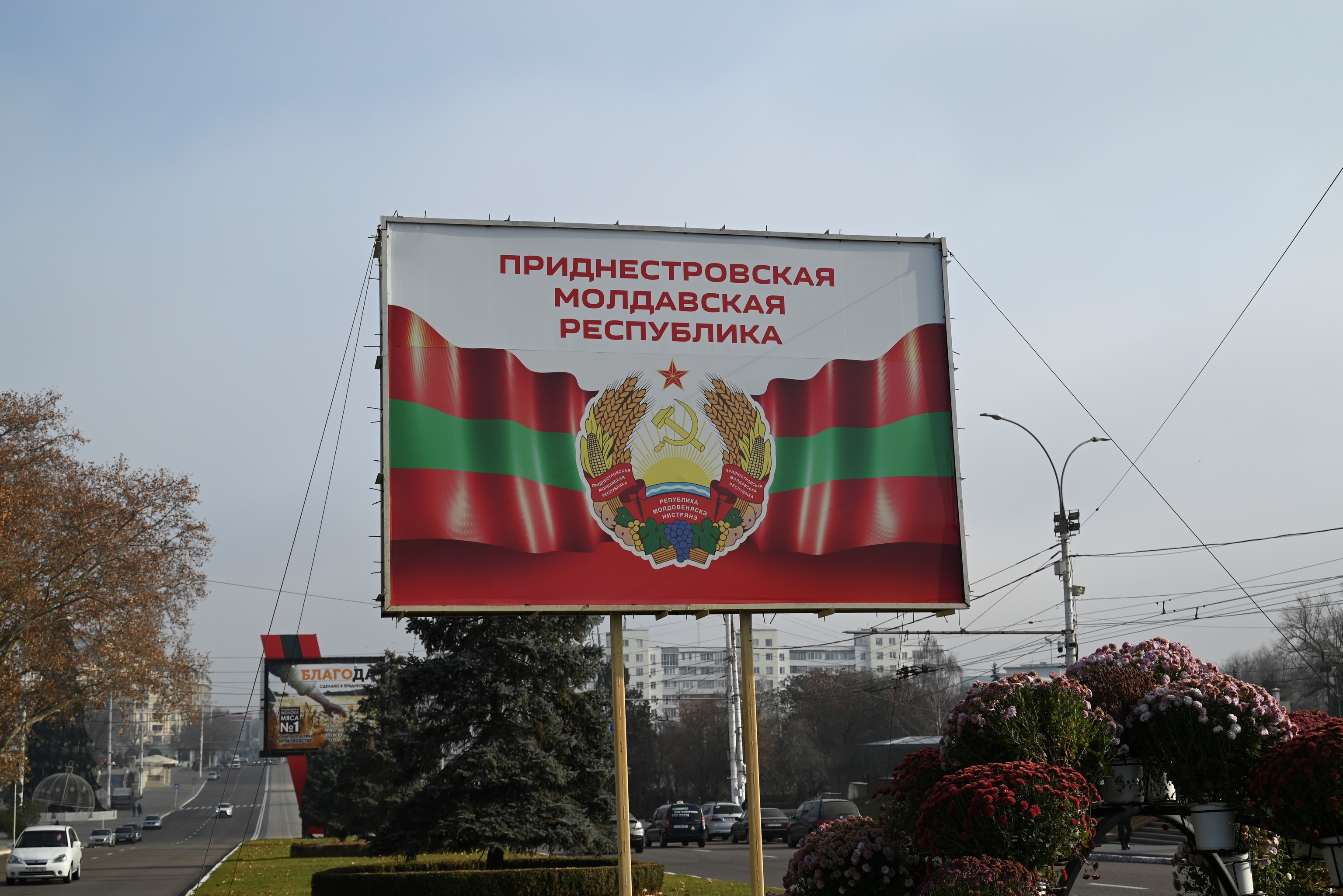 Un cartel con el escudo y la bandera de Transnistria