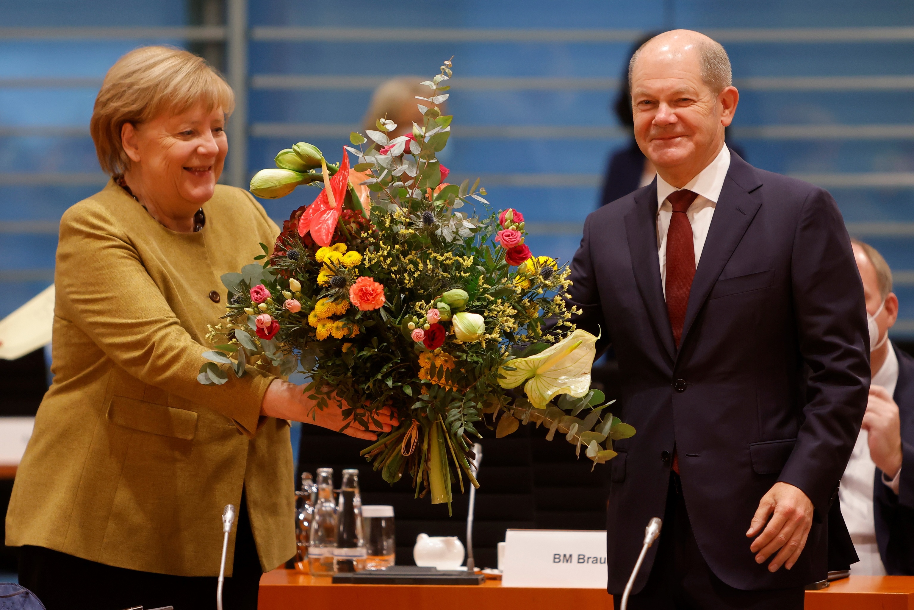 Merkel recibe un ramo de flores de Scholz.