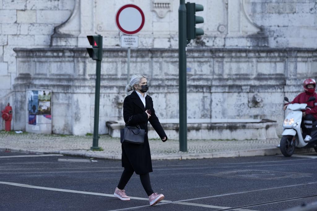 Una mujer con mascarilla pasea por Lisboa.