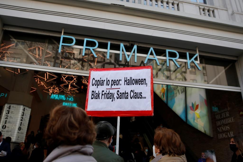 Un hombre sostiene un cartel frente a la tienda de Primark