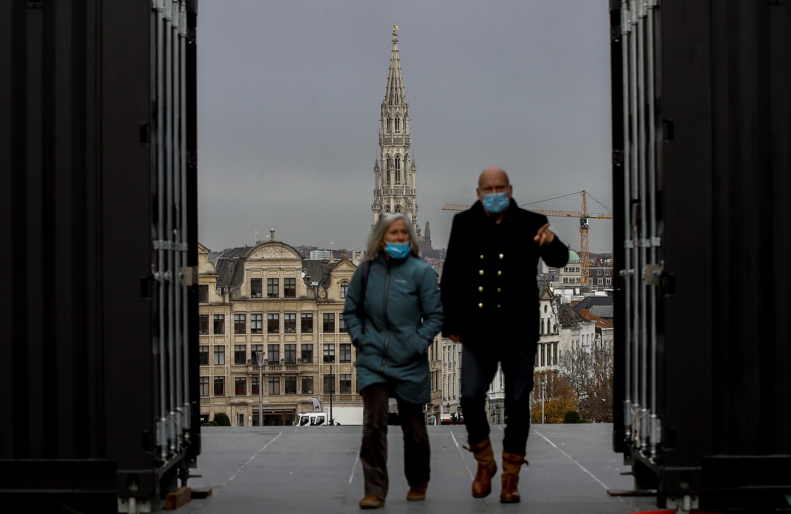 Dos personas en Bruselas con mascarilla para prevenir el coronaviru.