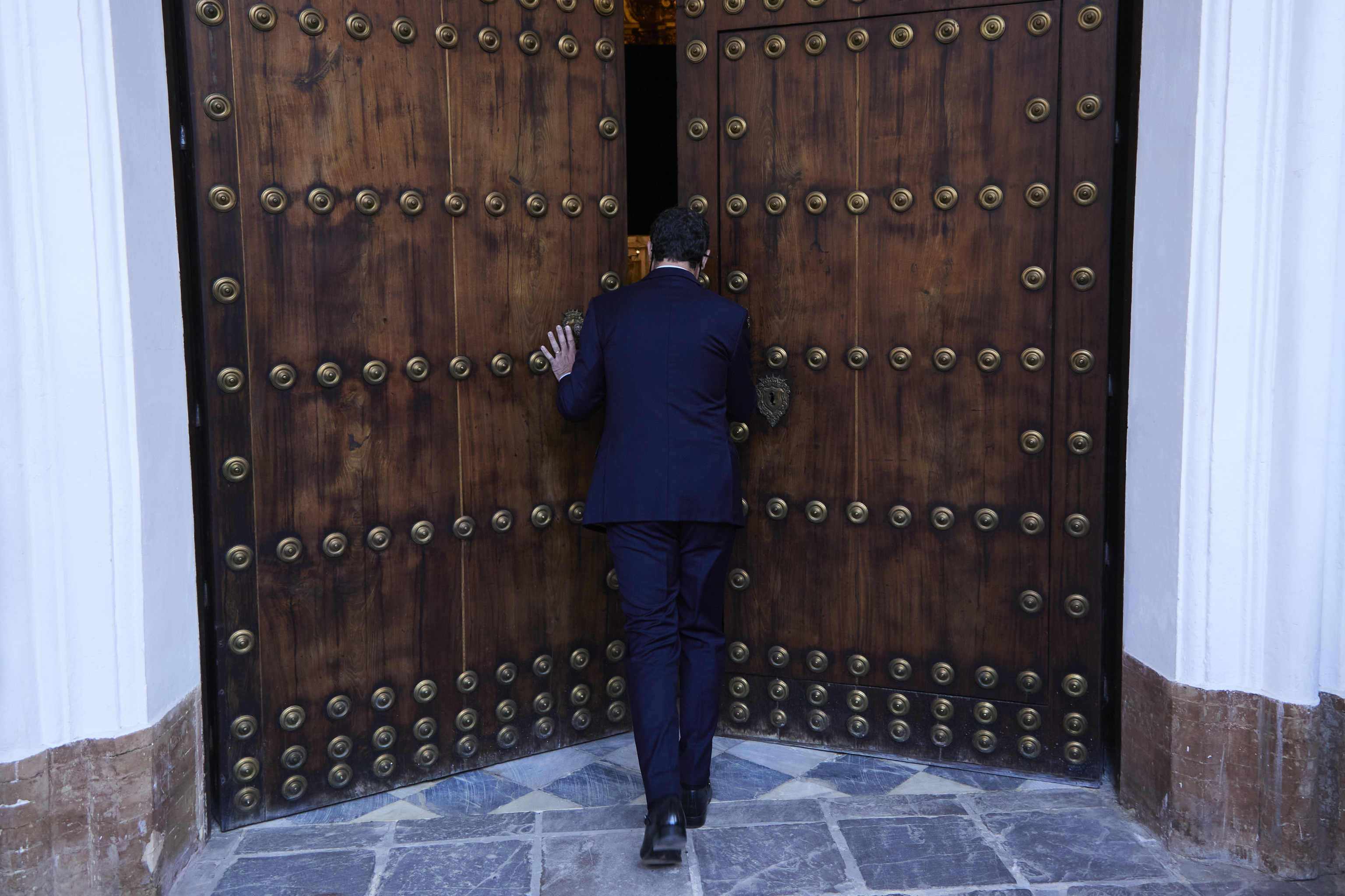 El presidente de la Junta, Juanma Moreno, abriendo las puertas de la capilla del Palacio de San Telmo este lunes para inaugurar el belén navideño.