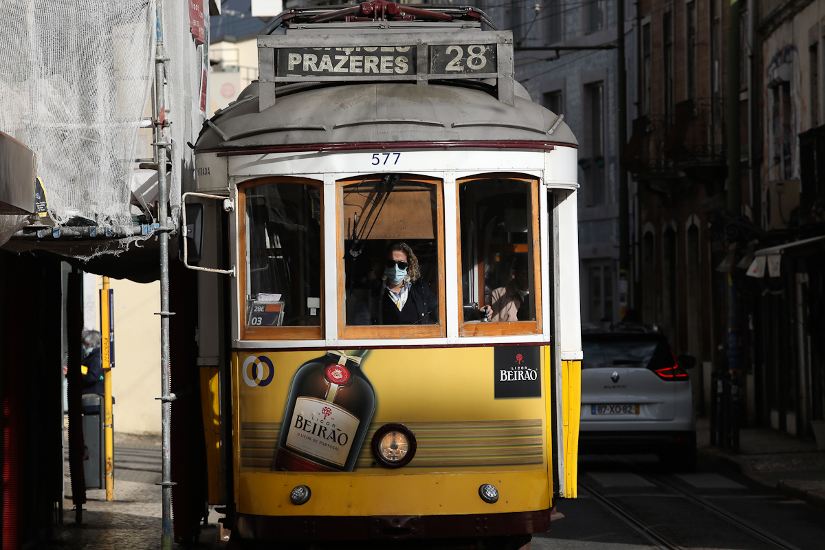 Un conductor con mascarilla conduce un tranvía en Lisboa.