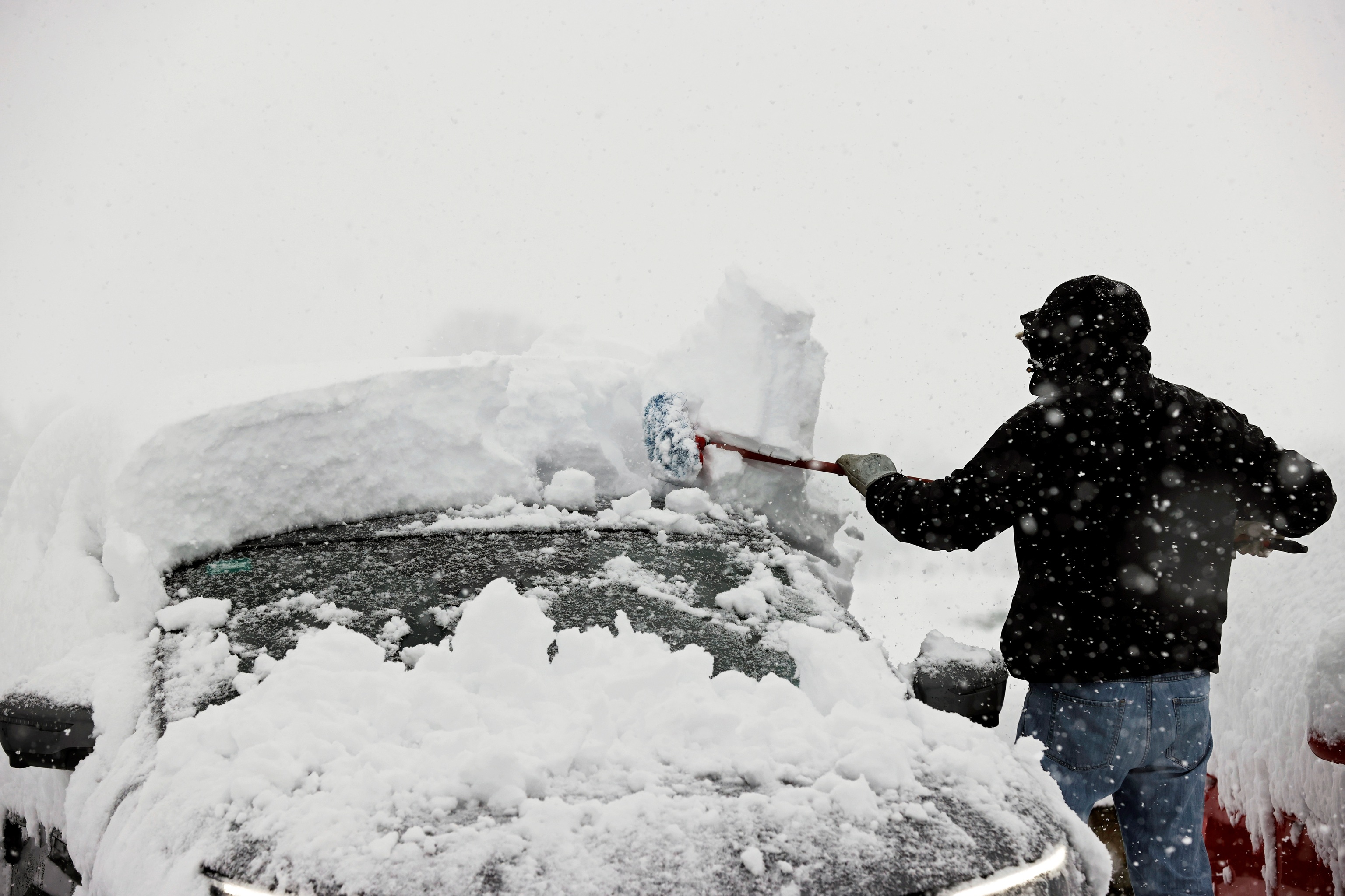 Una persona retira de su vehculo la nieve acumulada
