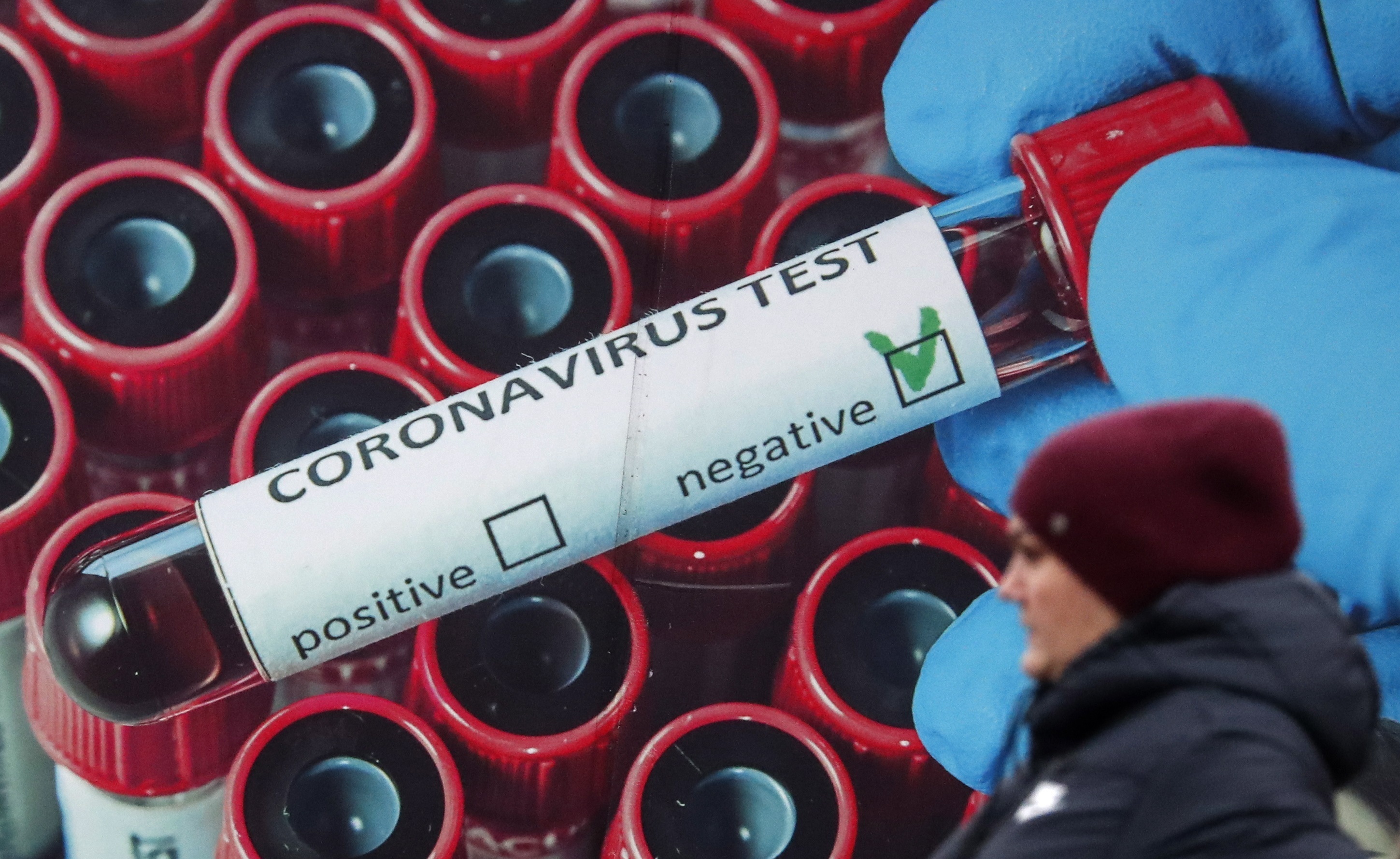 Una mujer junto a un cartel de promoción de test para detectar infecciones por Covid en Moscú.