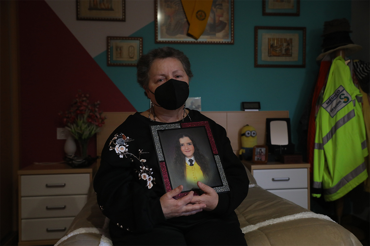 Teresa López, madre de Sara Bravo, posa con un retrato de la doctora en su habitación.