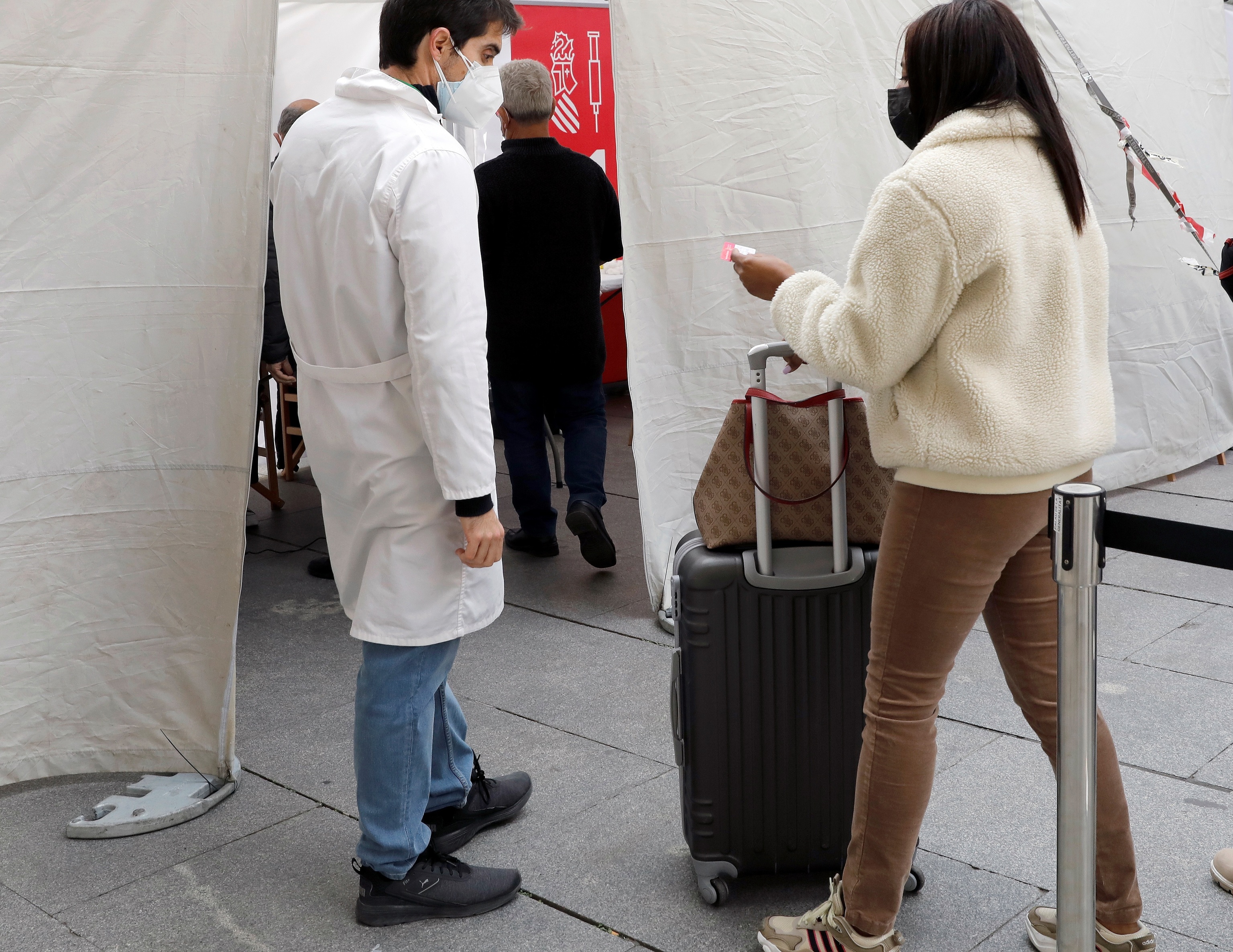Una joven acude con su maleta a un punto de vacunación móvil contra el Covid-19.
