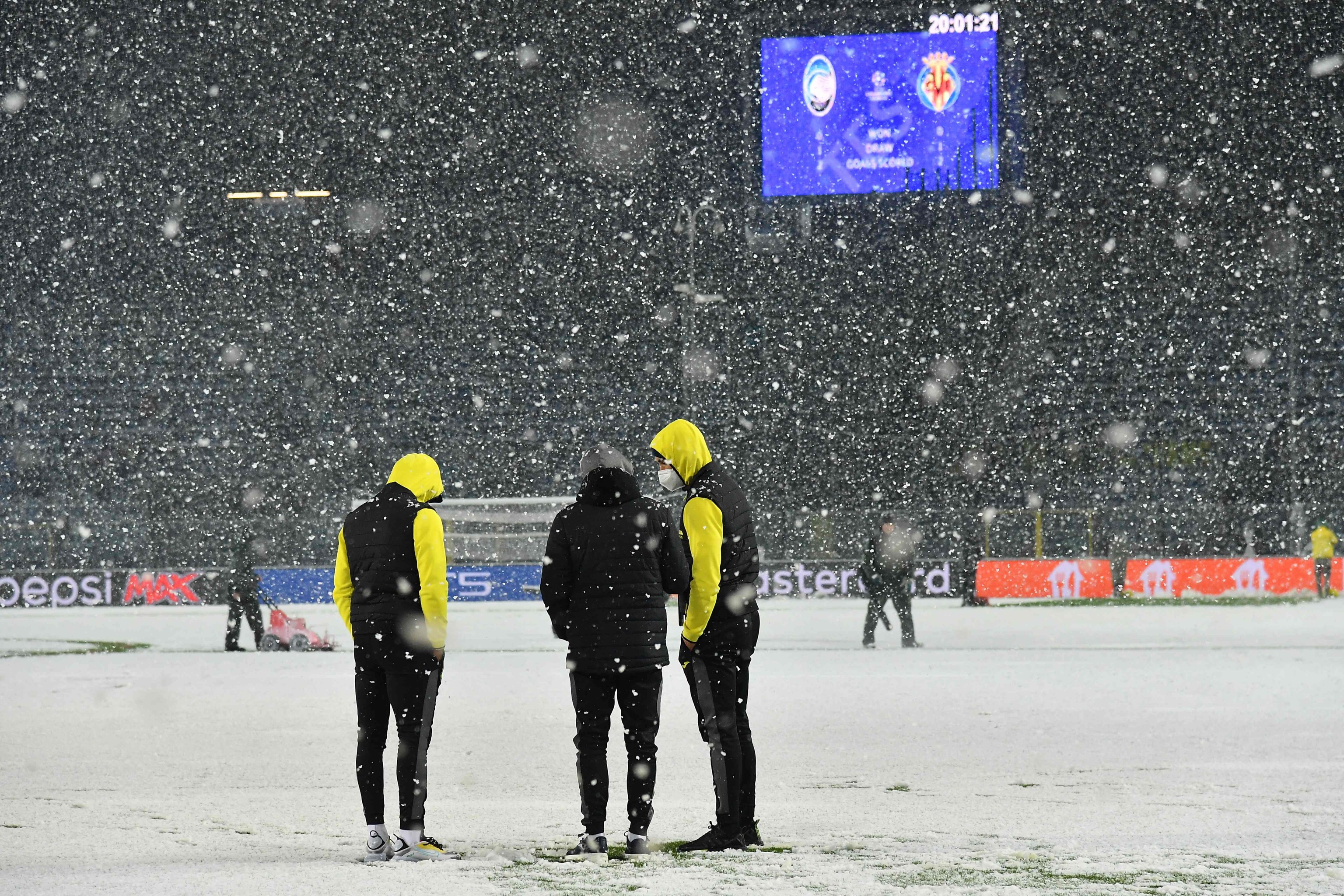Los jugadores del Villarreal, bajo la nieve en el campo del Atalanta.