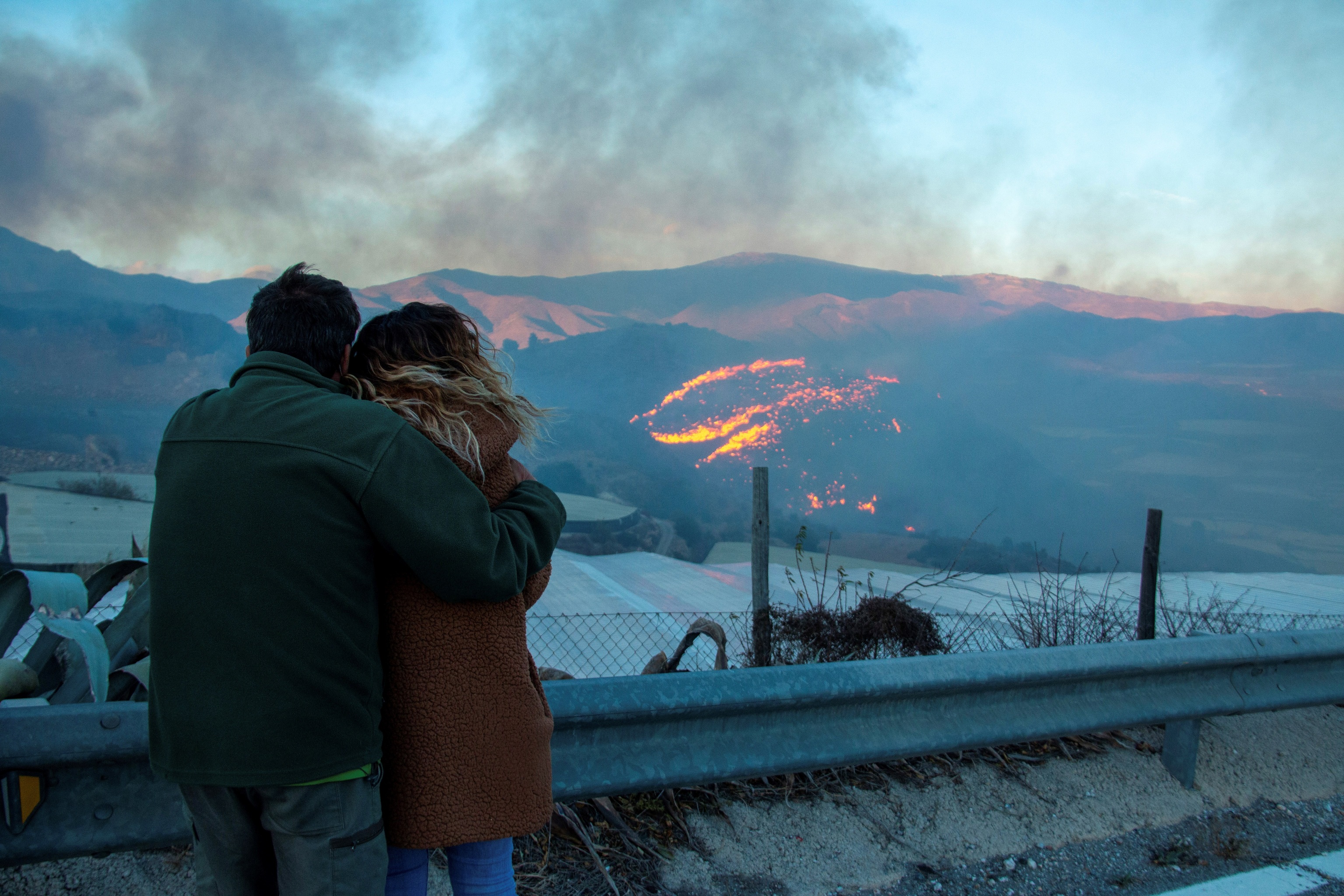 Dos personas contemplan el incendio forestal declarado en Gualchos