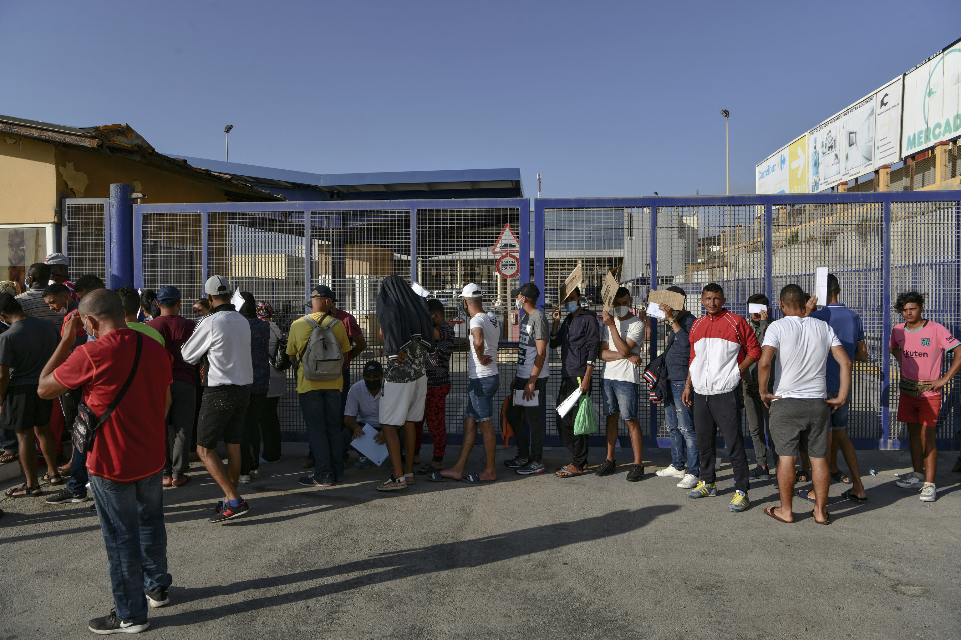 Varios inmigrantes a las puertas de la frontera del Tarajal, en Ceuta.