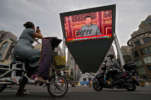 Una mujer fotografa a Xi Jinping en una pantalla en Pekn.