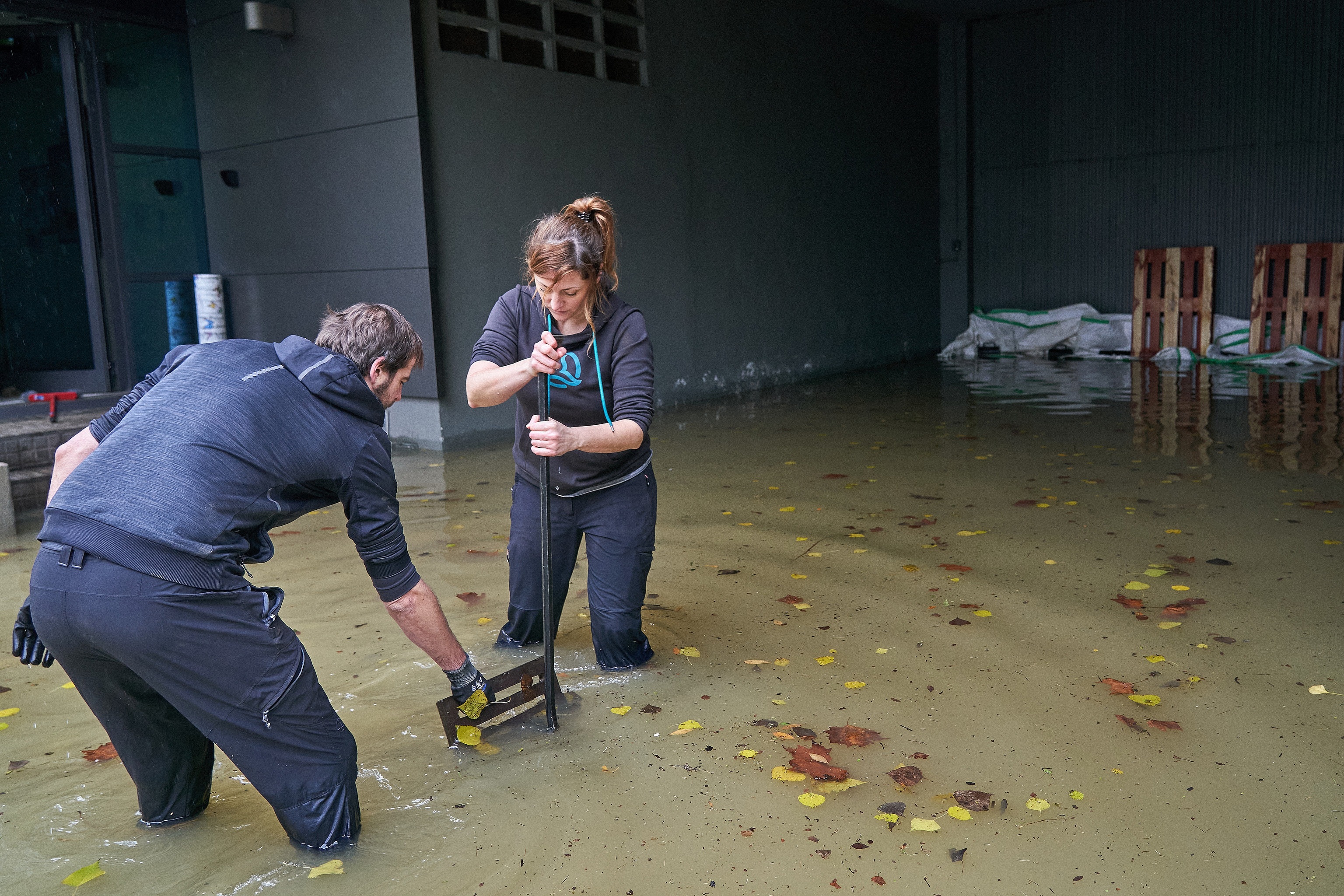 Dos trabajadores intentan achicar agua en uno de los pabellones inundados en Gamarra en la periferia de Vitoria.