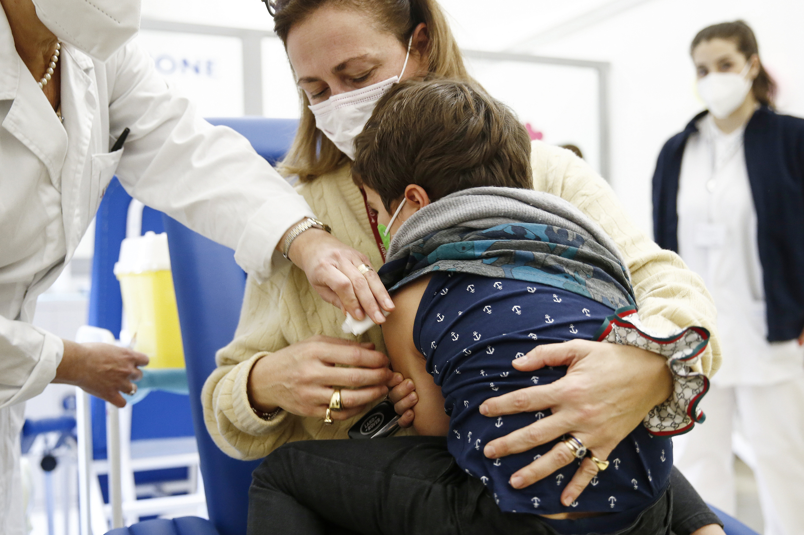 Un nio se consuela en su madre tras recibir la vacuna contra el Covid-19.