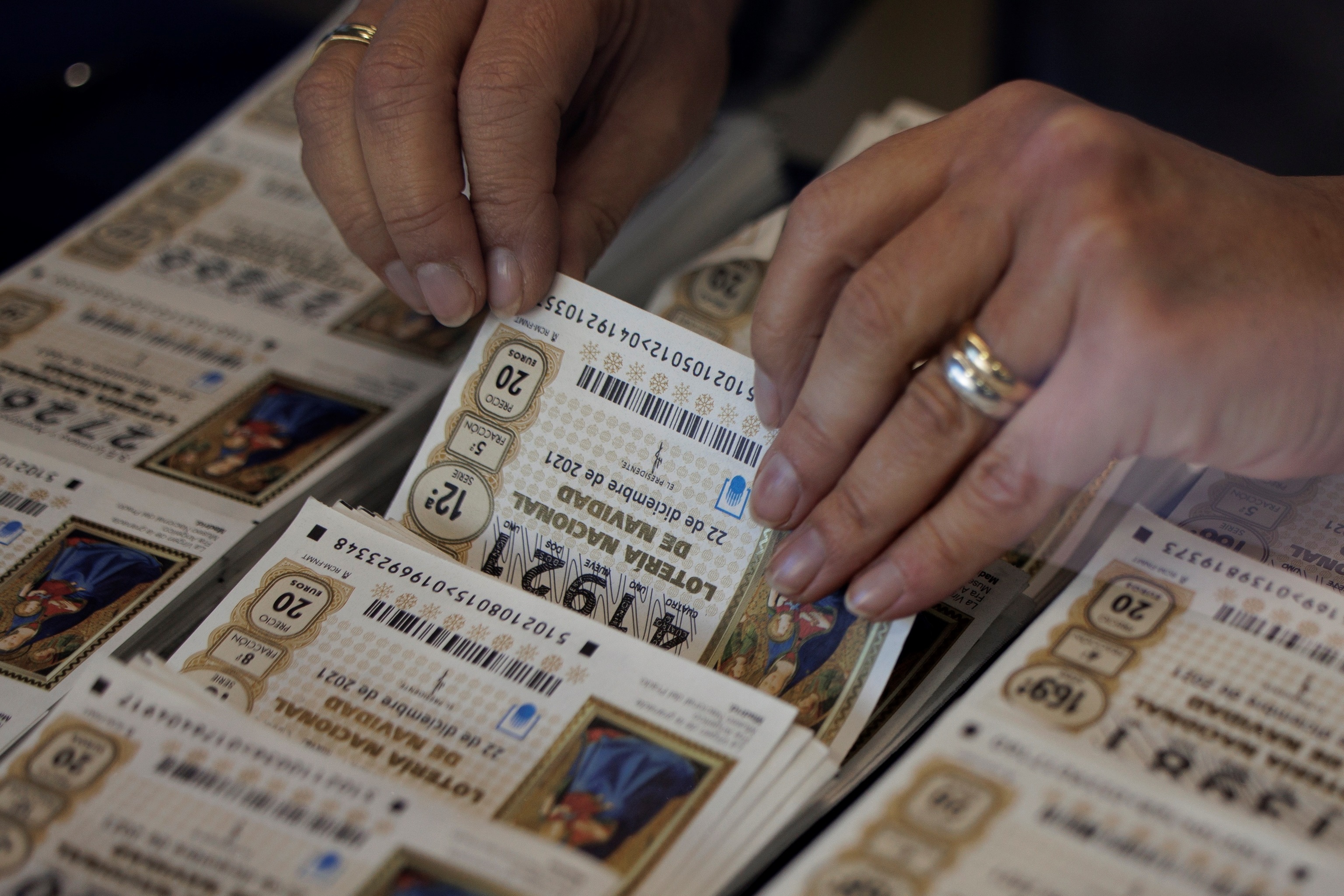 Una lotera revisa varios dcimos para el Sorteo de la Lotera de Navidad de 2021 en una administracin de Valencia.