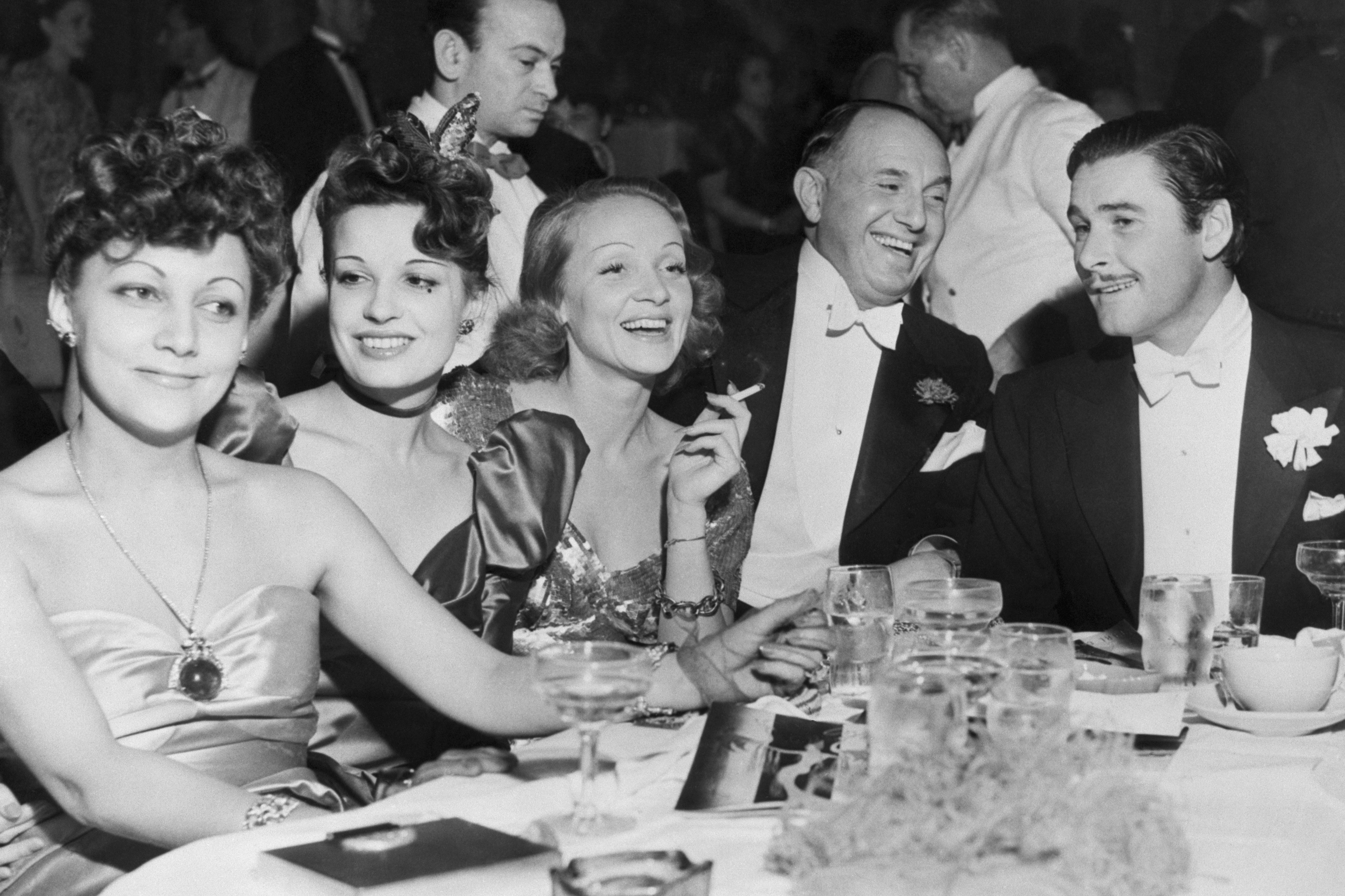 De izq. a dcha., la seora Warner, Lily Damita, Marlene Dietrich, Jack Warner y Errol Flynn en una fiesta en Hollywood.