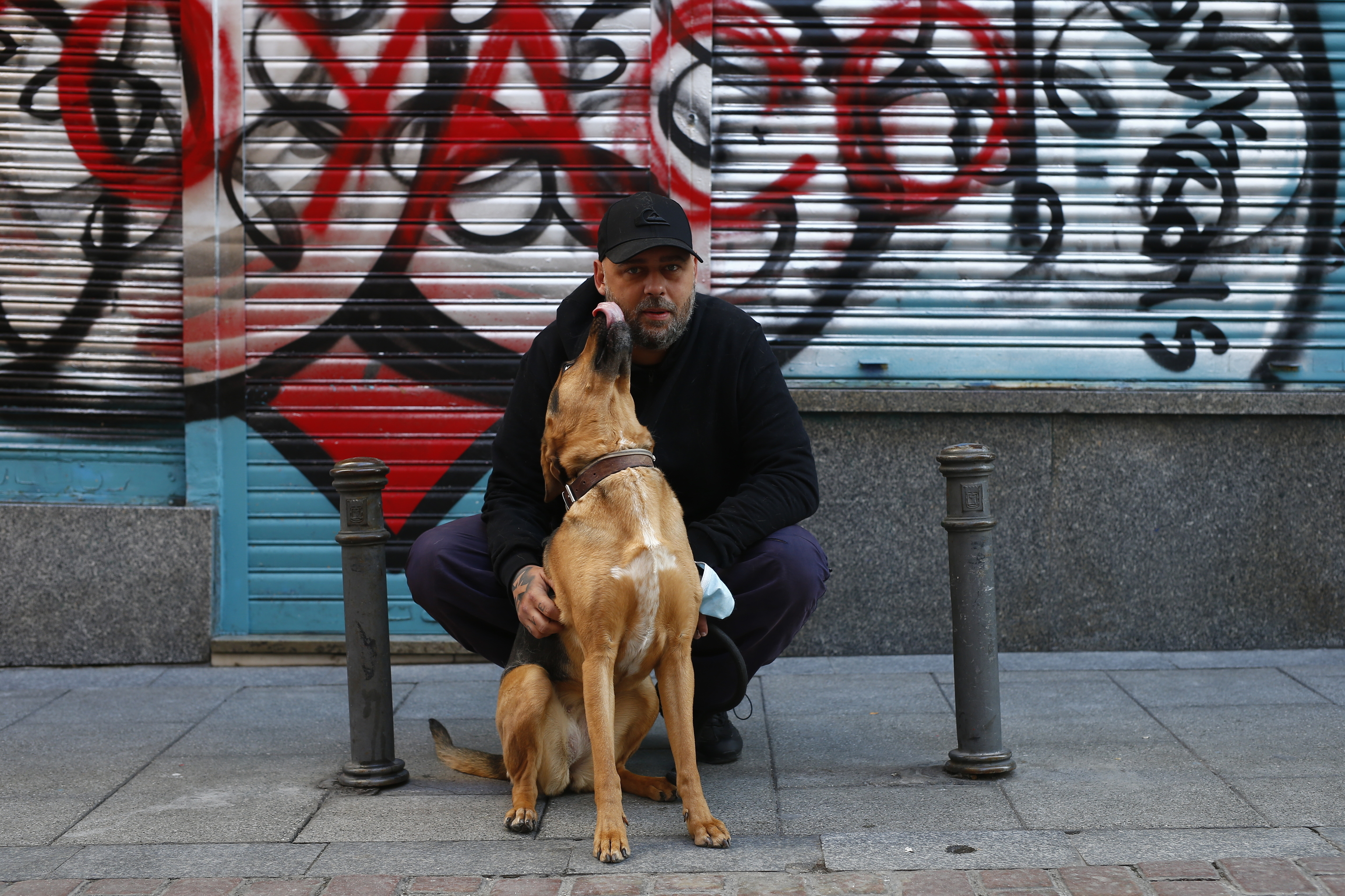 Jony, el mendigo que salió de la calle gracias a Twitch, junto a su perra Duna cerca de la casa que ha estrenado en Malasaña. JAVIER BARBANCHO