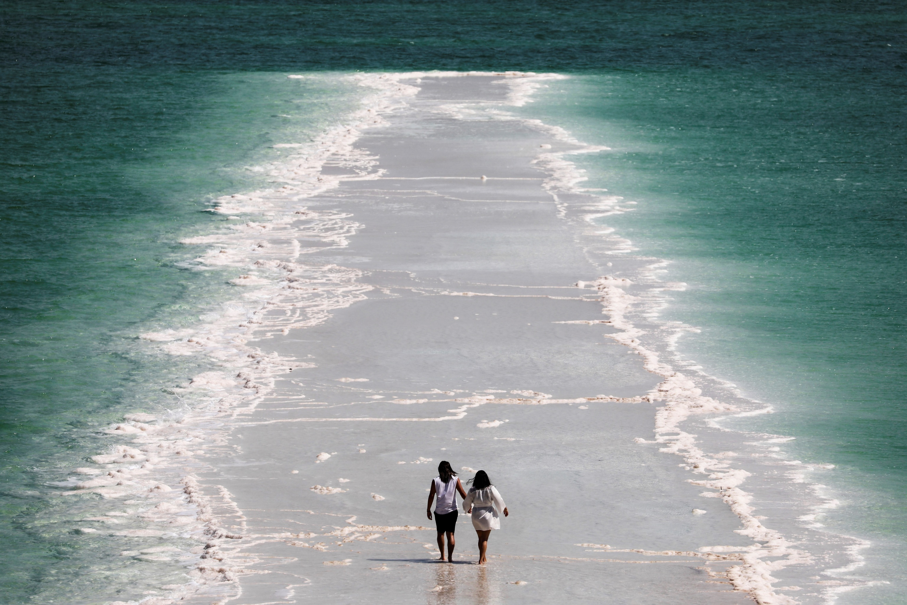 Una pareja paseando por una zona de playa.