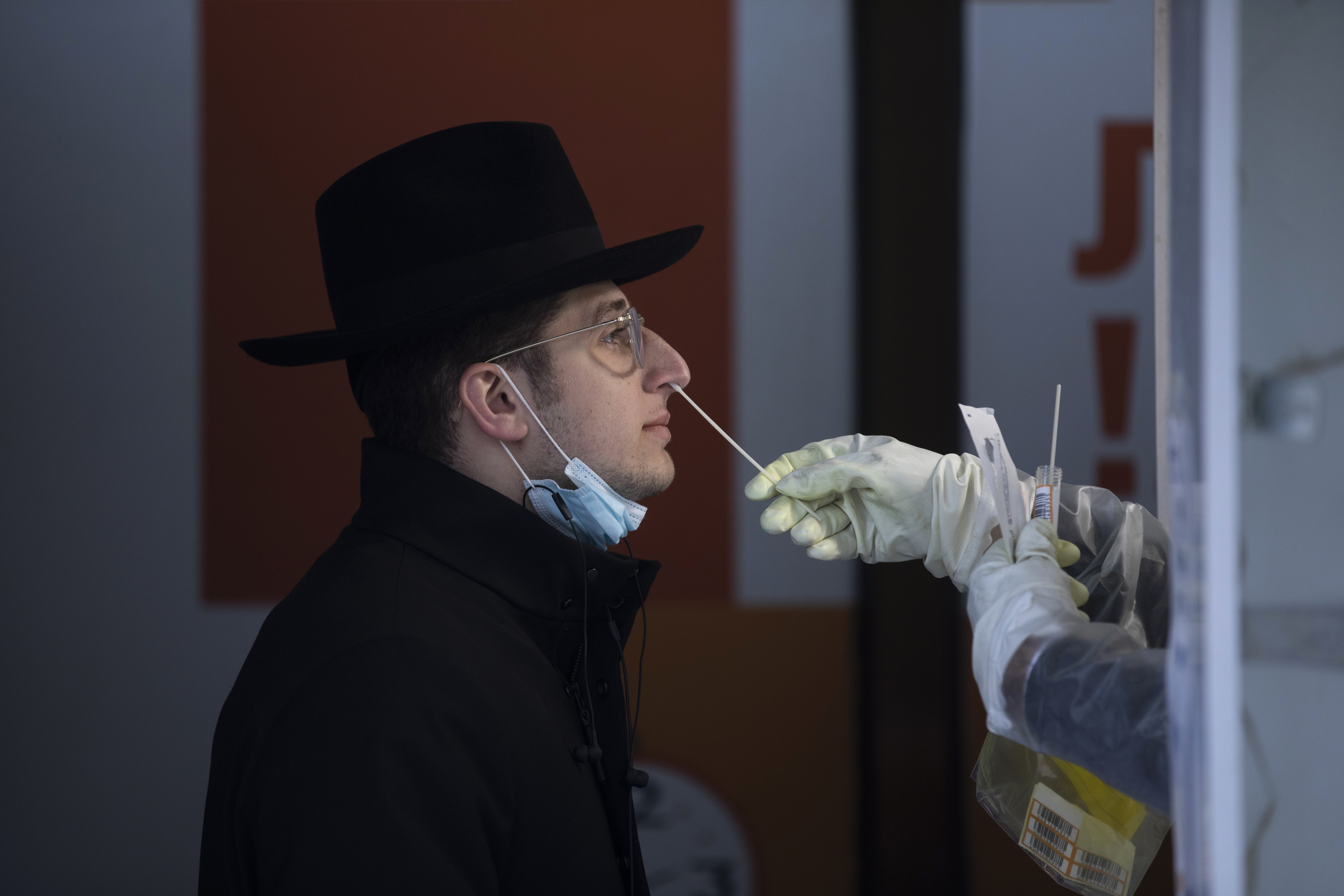 Un sanitario realiza un test Covid a un estudiante judío ultraortodoxo no vacunado en un centro de Jerusalén.