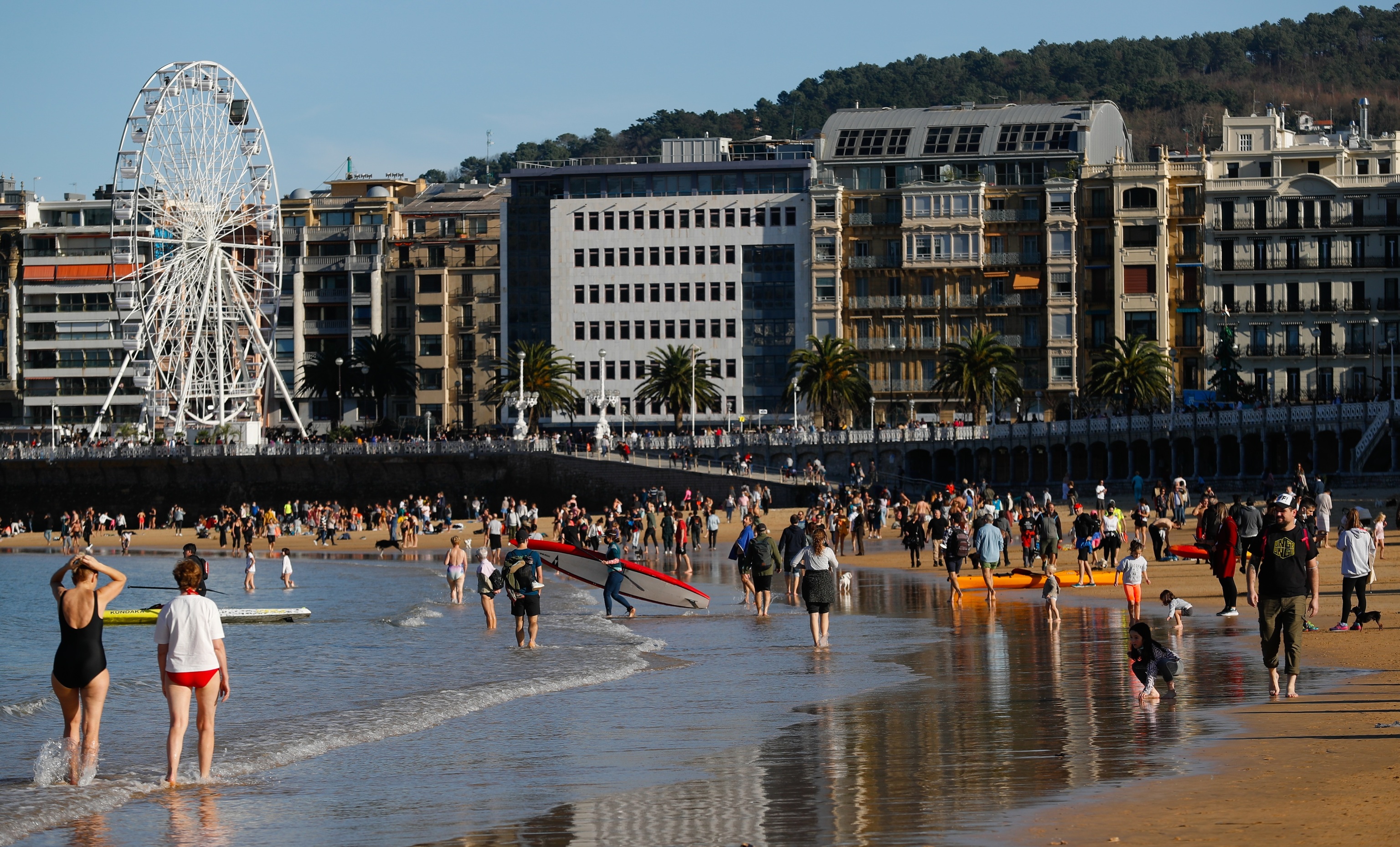 Turistas disfrutan de un dïa soleado con altas temperaturas en la playa de la Concha de San Sebastián
