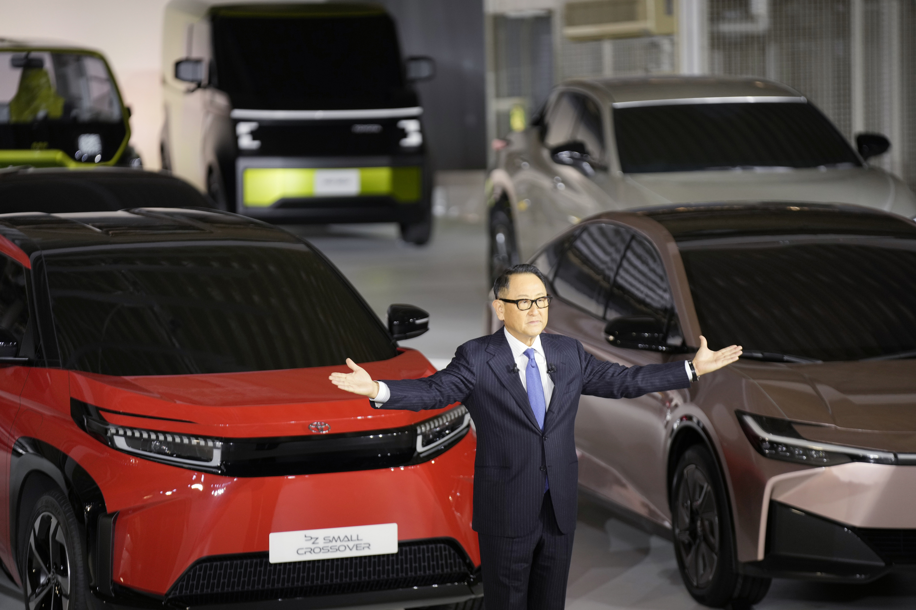 Toyota President Akio Toyoda speaks in front of some of the new veh