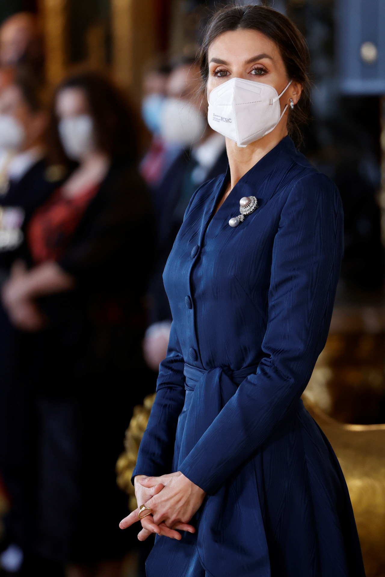 La Reina, de nuevo con el broche sobre su vestido azul marino.