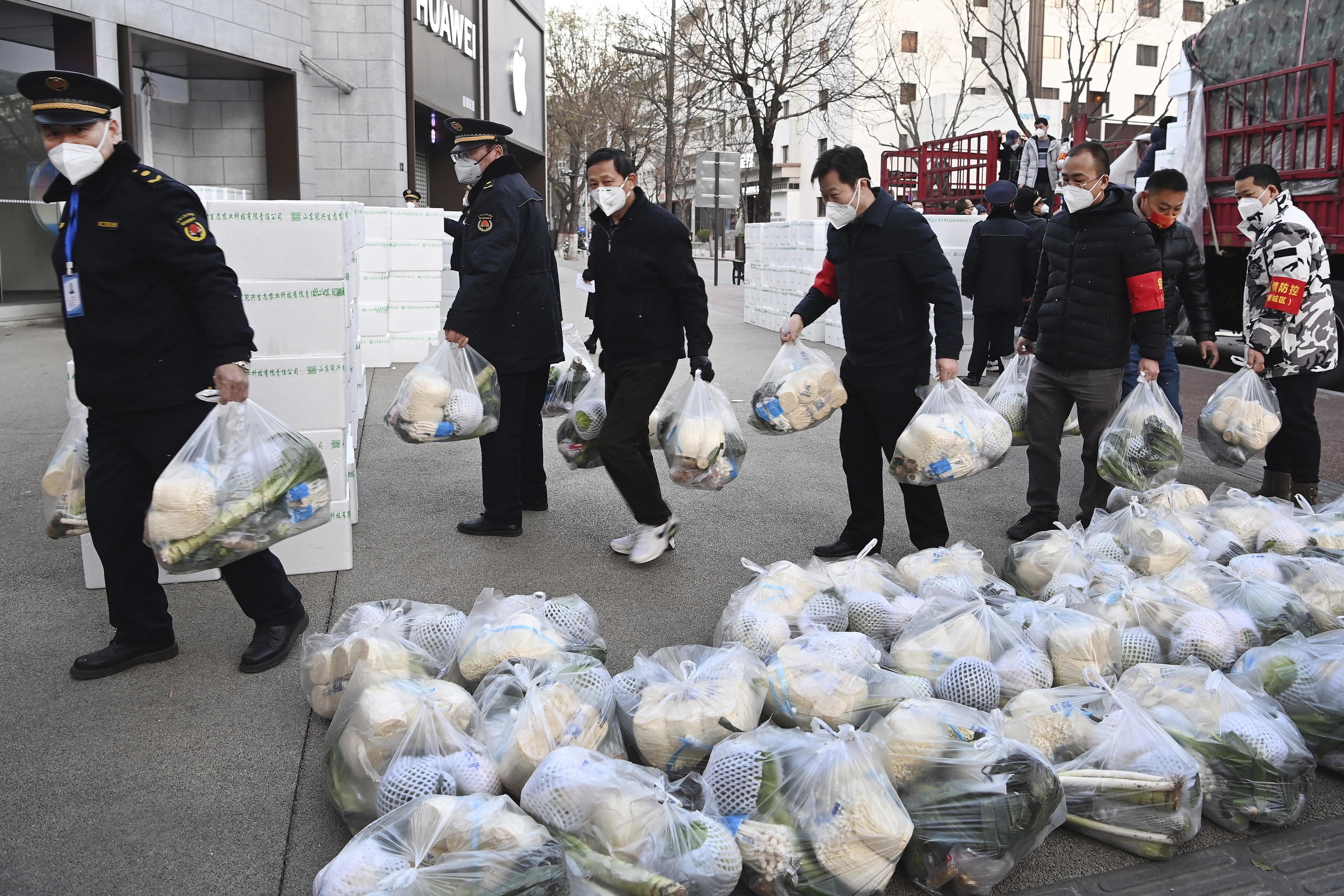 Funcionarios reparten bolsas de comida entre los habitantes de Xian.