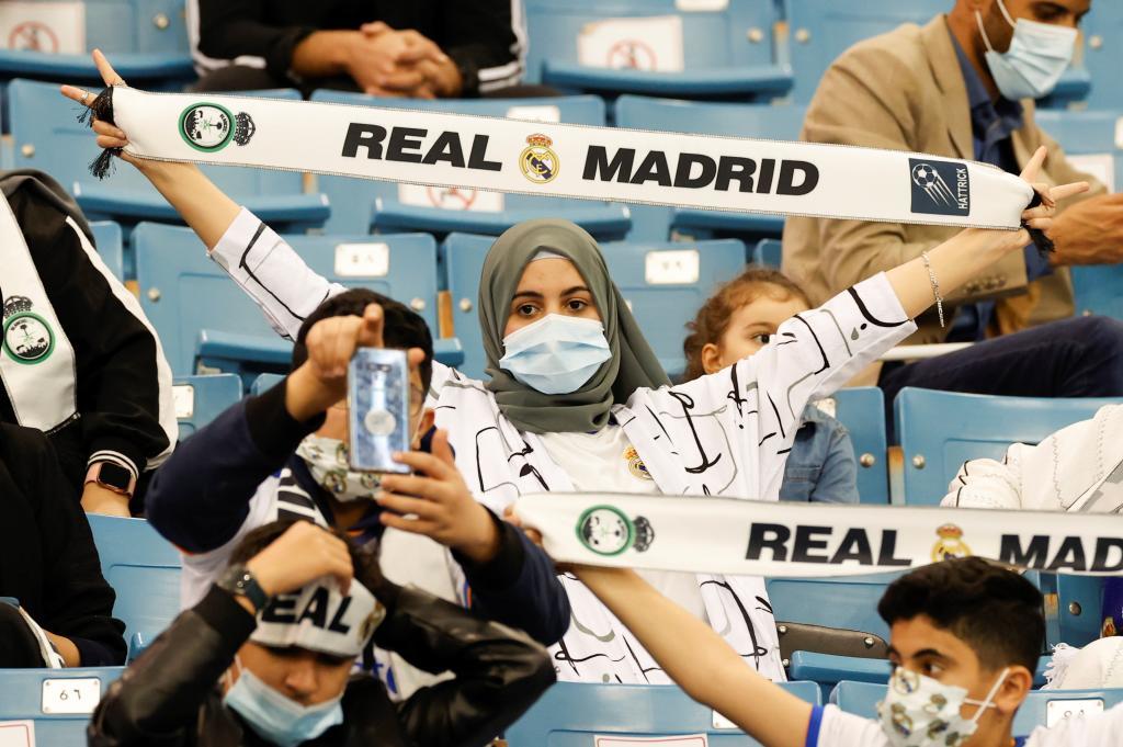 Una mujer, con una bufanda del Real Madrid.