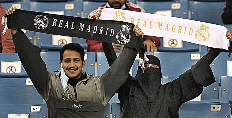 Una aficionada sostiene una bufanda del Real Madrid.