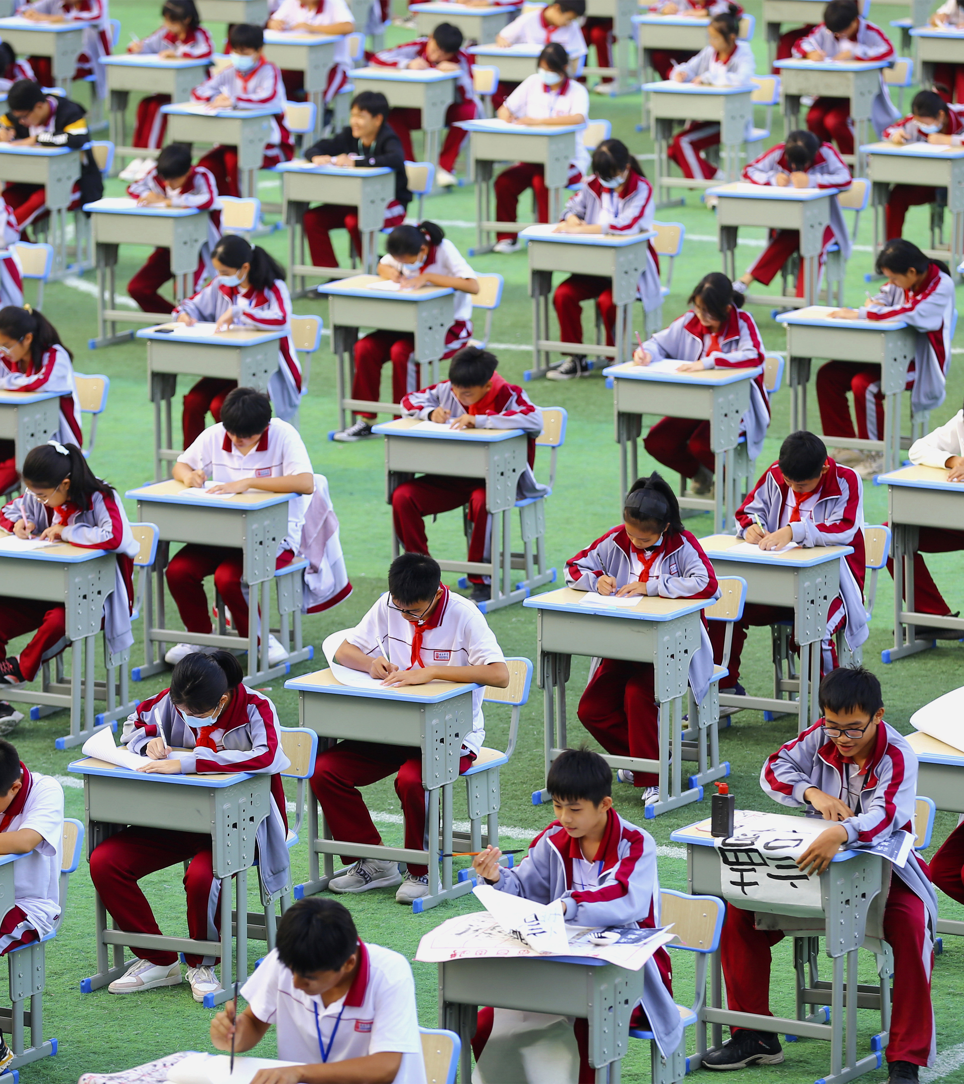 Miles de estudiantes chinos participan en un concurso de caligrafía en una escuela de la provincia de Hainan.