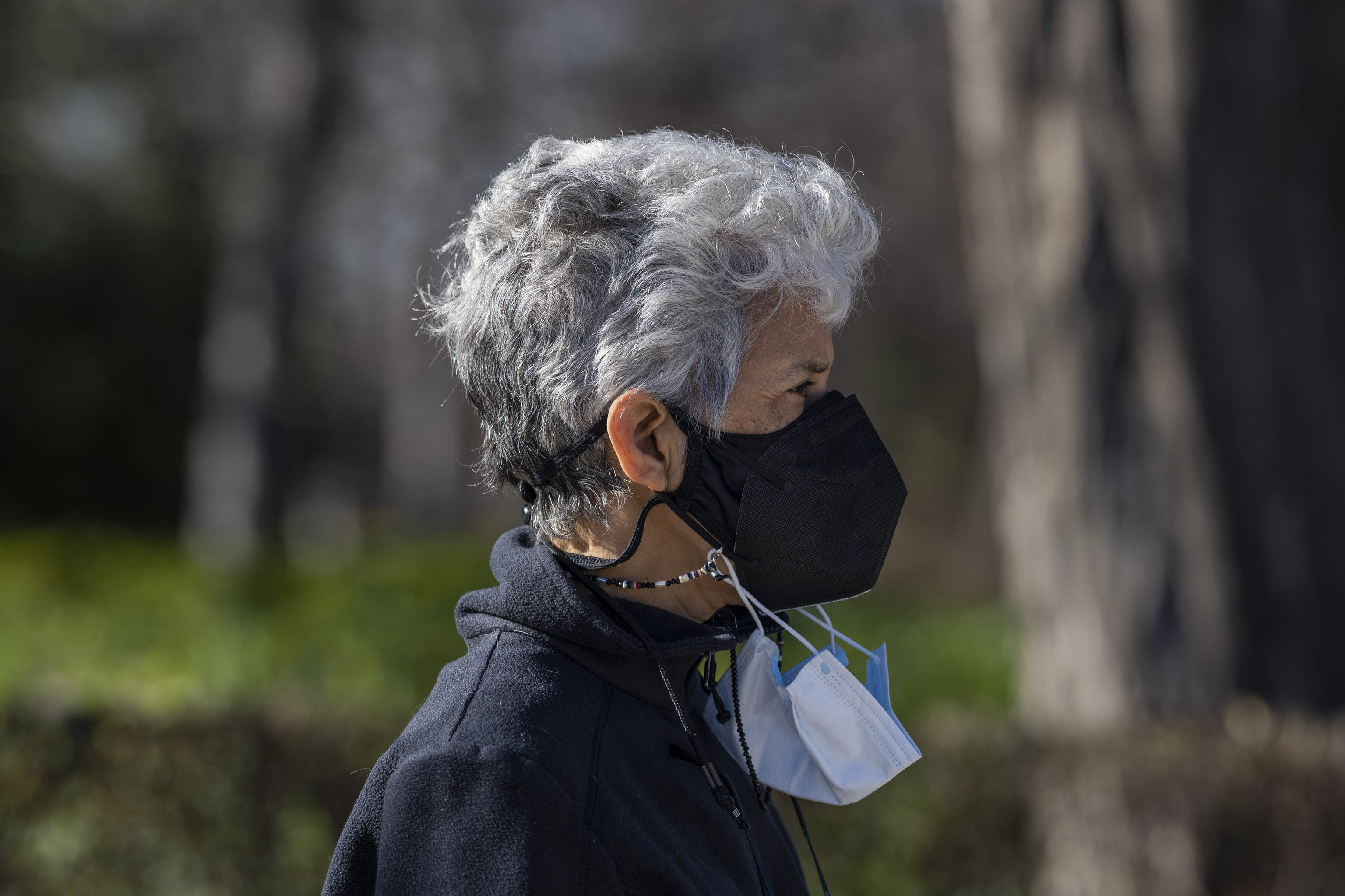 Una mujer con dos mascarillas en el Parque del Retiro de Madrid