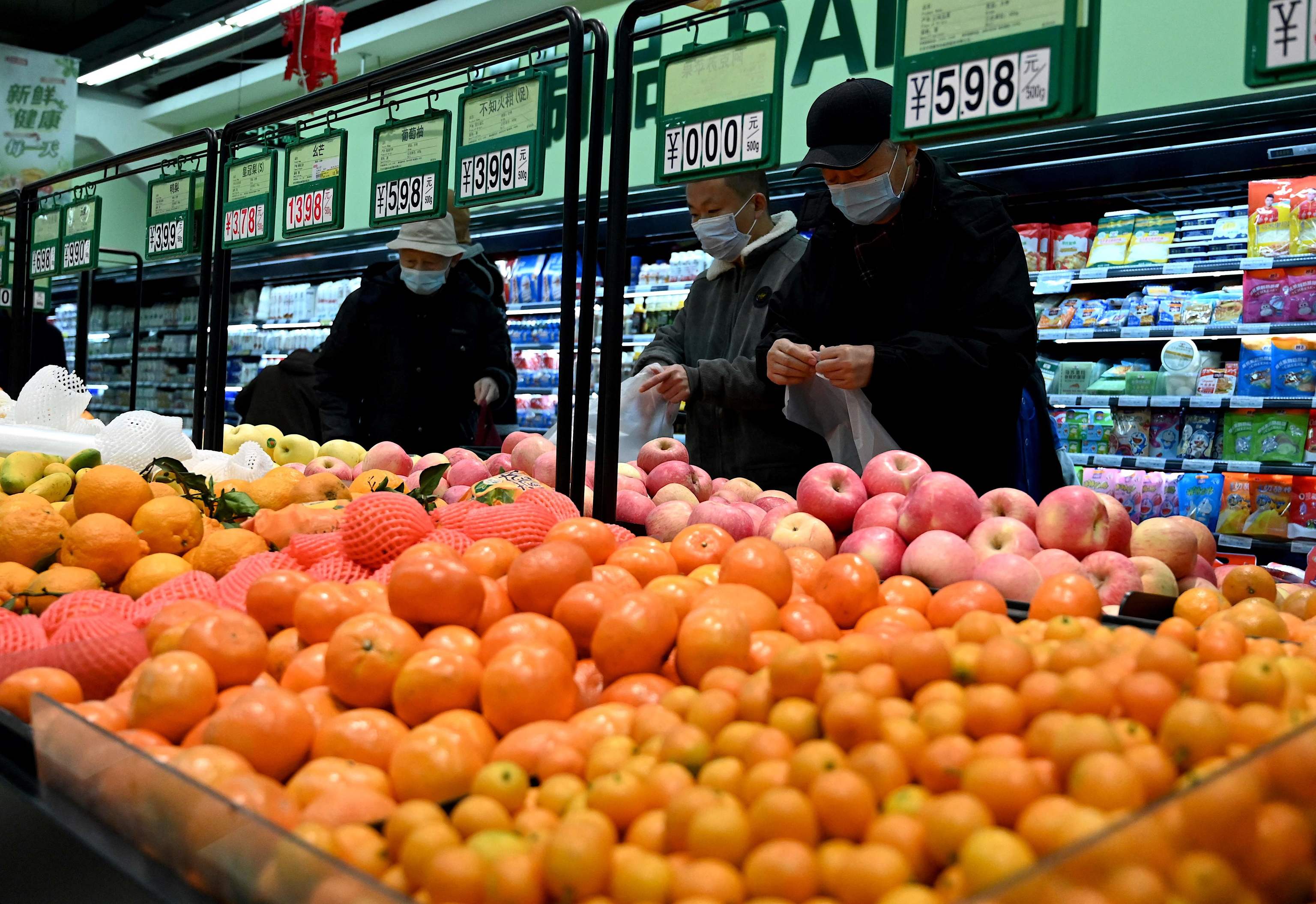 Varios ciudadanos compran fruta en un mercado de Pekín.