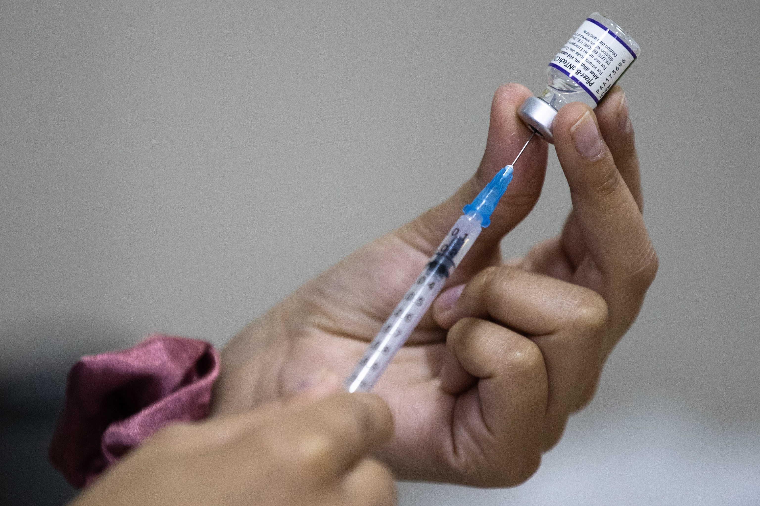 Una enfermera prepara una jeringa con una dosis de la vacuna Pzfier contra la covid-19 e un centro de vacunacin.